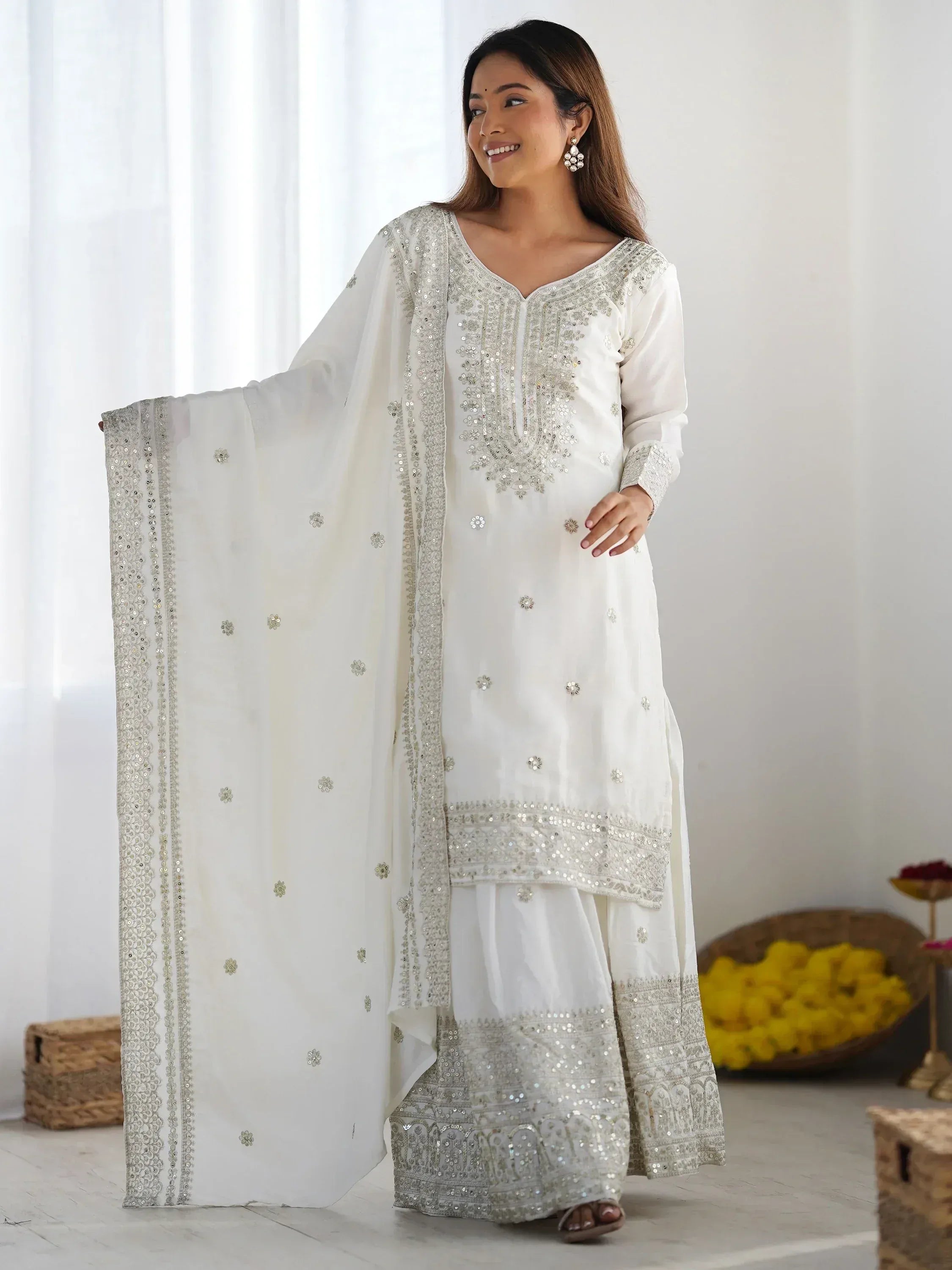 White embroidered salwar kameez with sequin work and matching dupatta, ideal for ethnic occasions