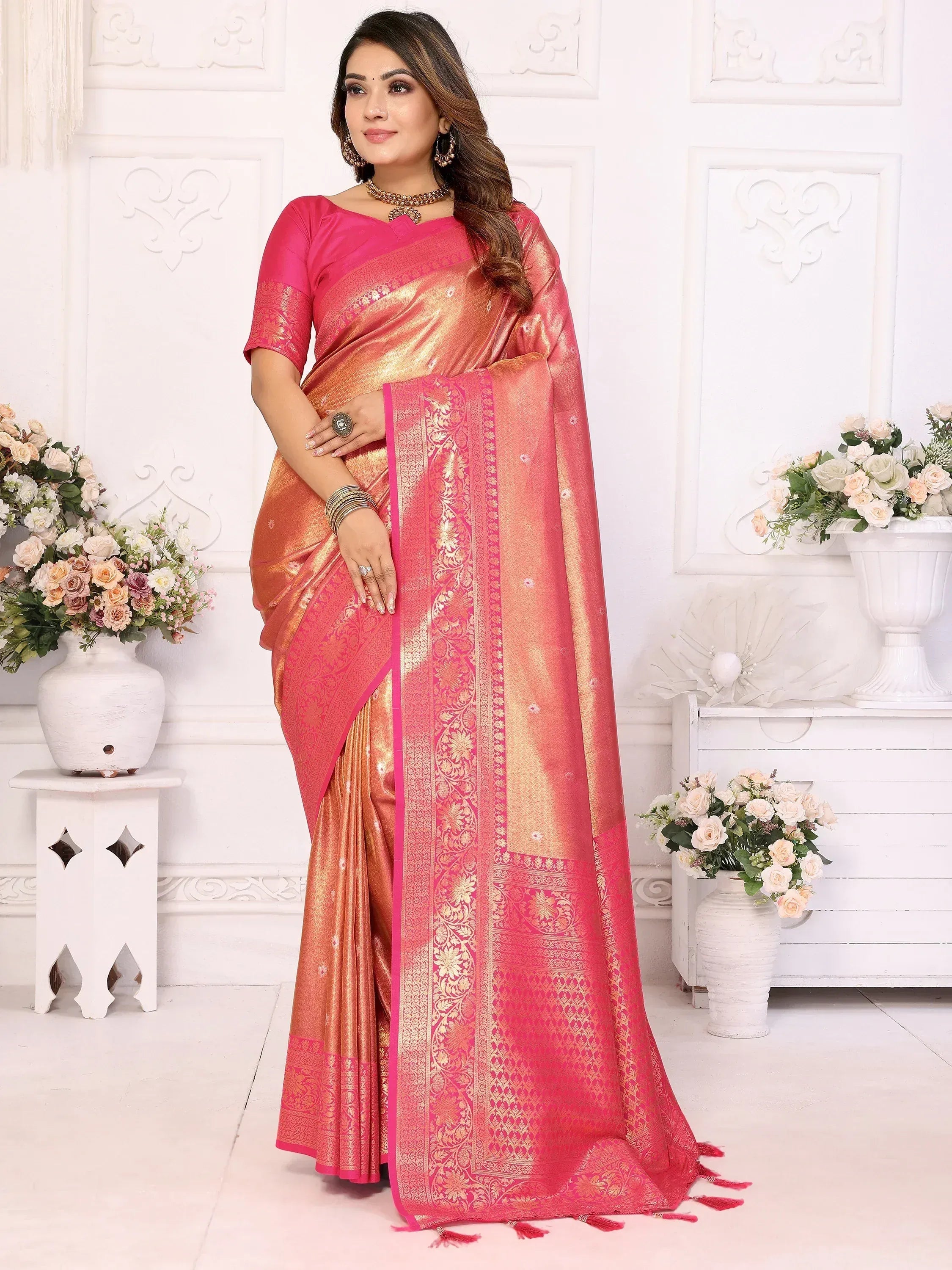 Elegant pink and gold designer saree with intricate embroidery and tassels, perfect for festive occasions.
