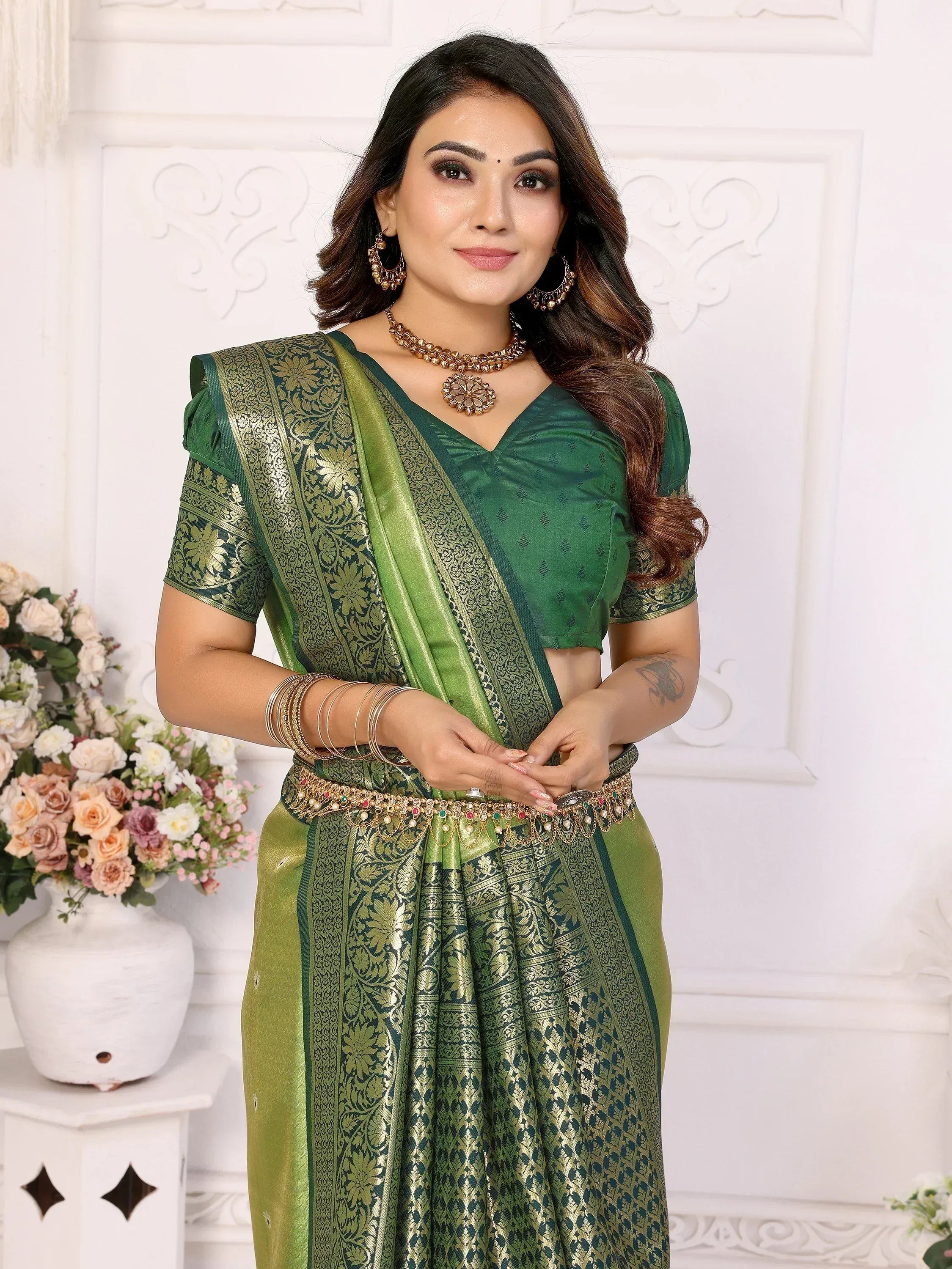 Green designer saree with gold embroidery, paired with matching blouse and traditional jewelry