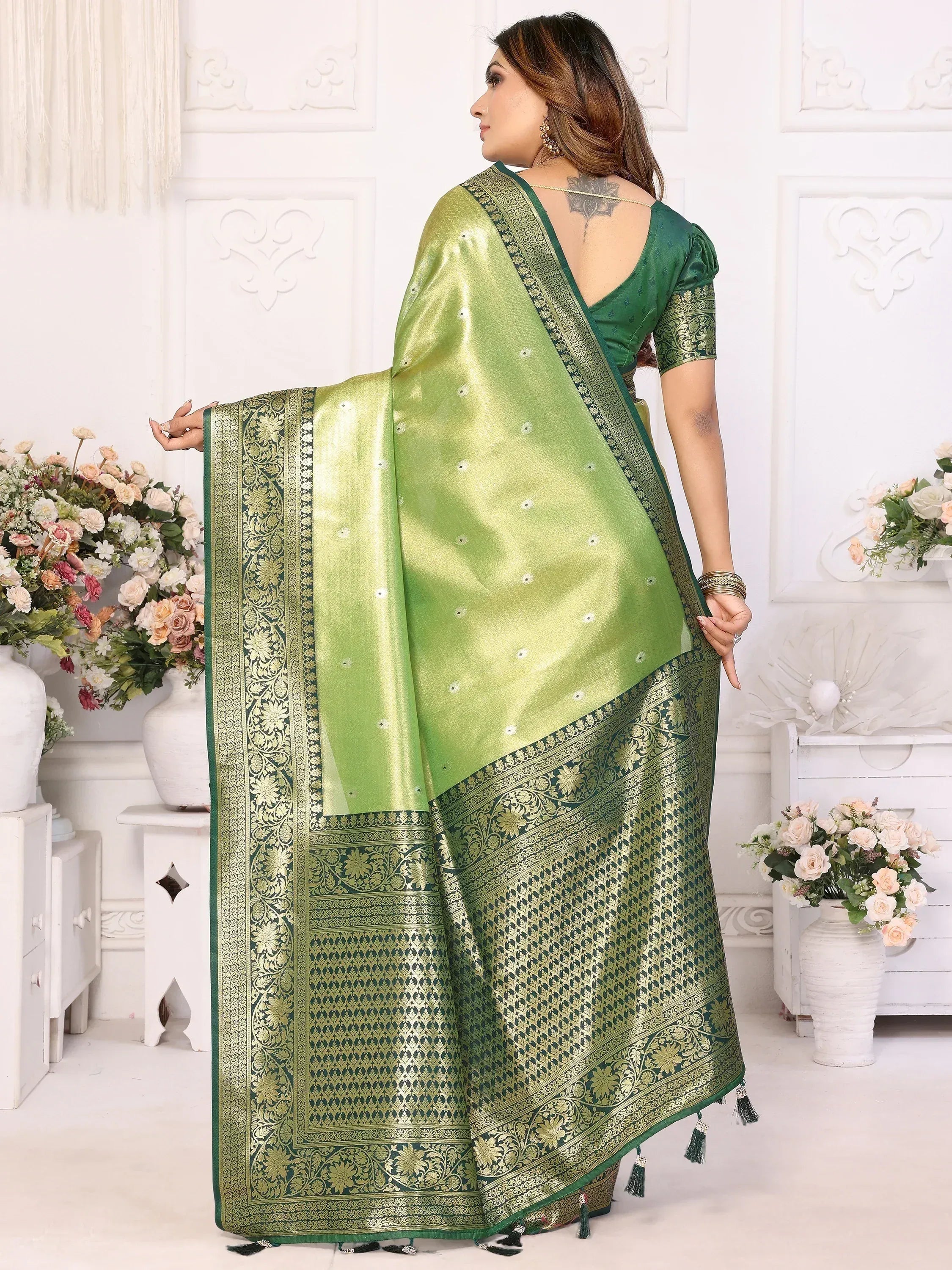 Green designer saree with gold embroidery and tassels, perfect for ethnic occasions