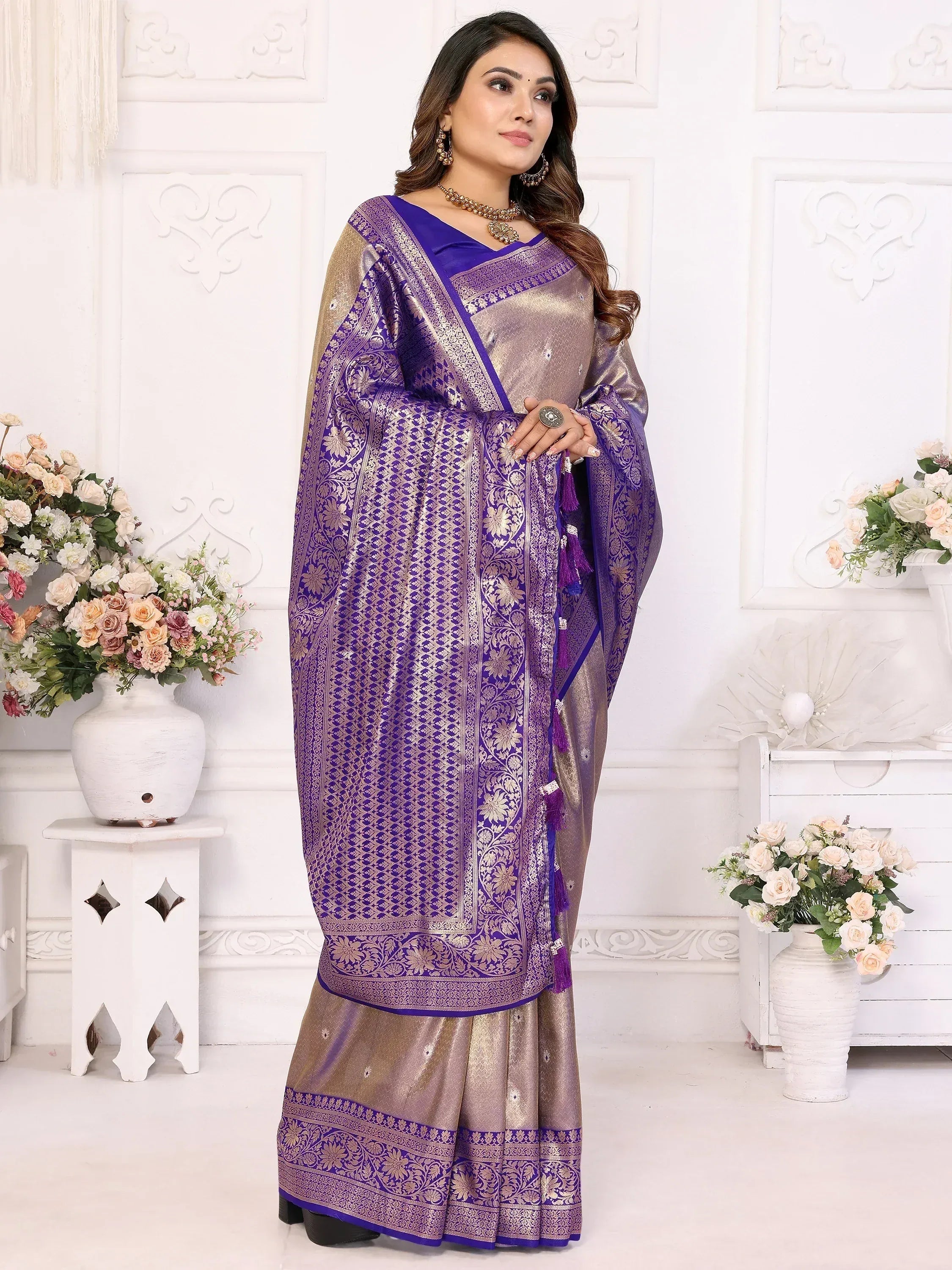 Purple and gold designer saree with intricate floral patterns and tassels, perfect for ethnic occasions.