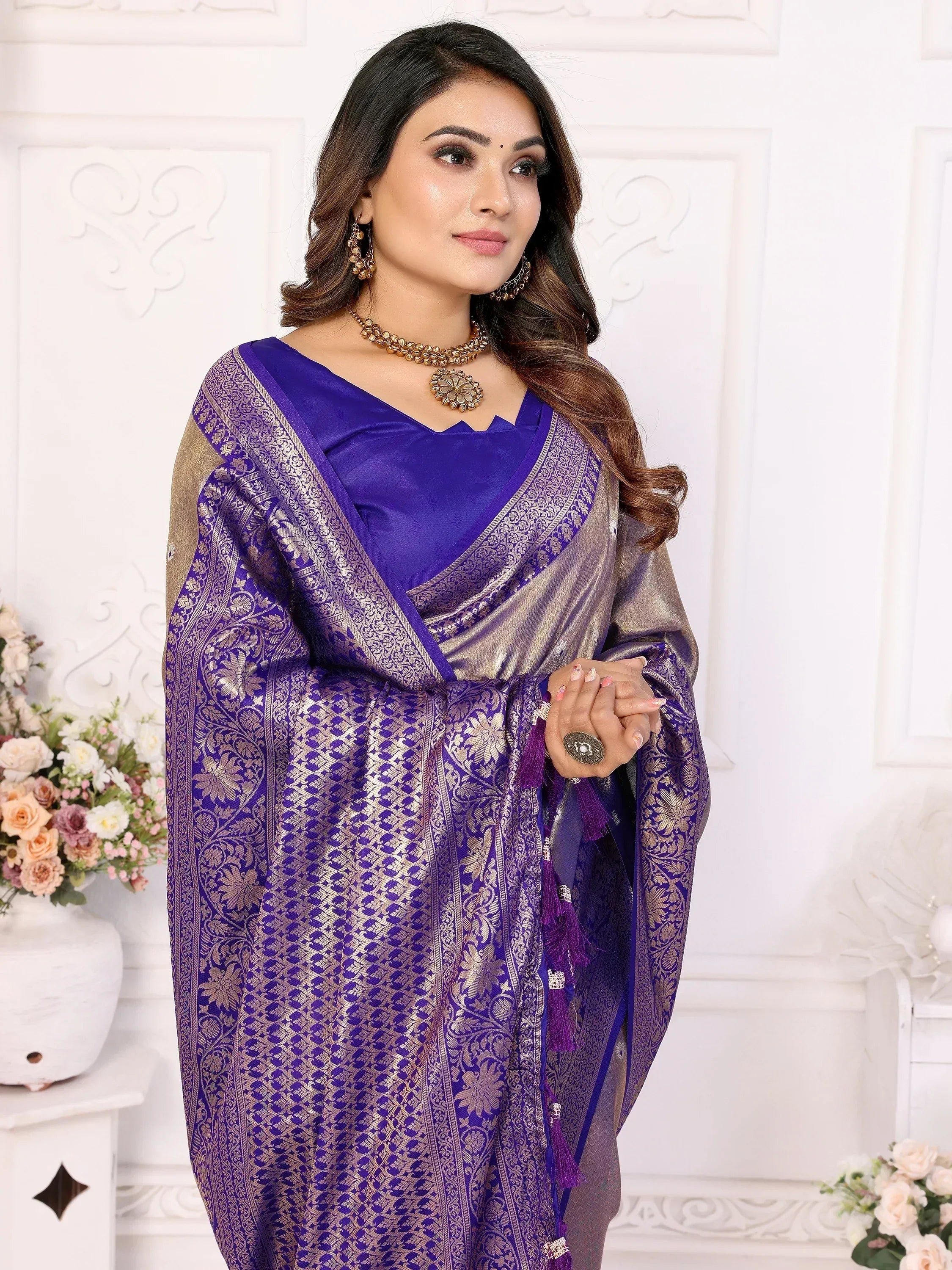 Purple and gold designer saree with intricate floral patterns and tassels, perfect for ethnic occasions.