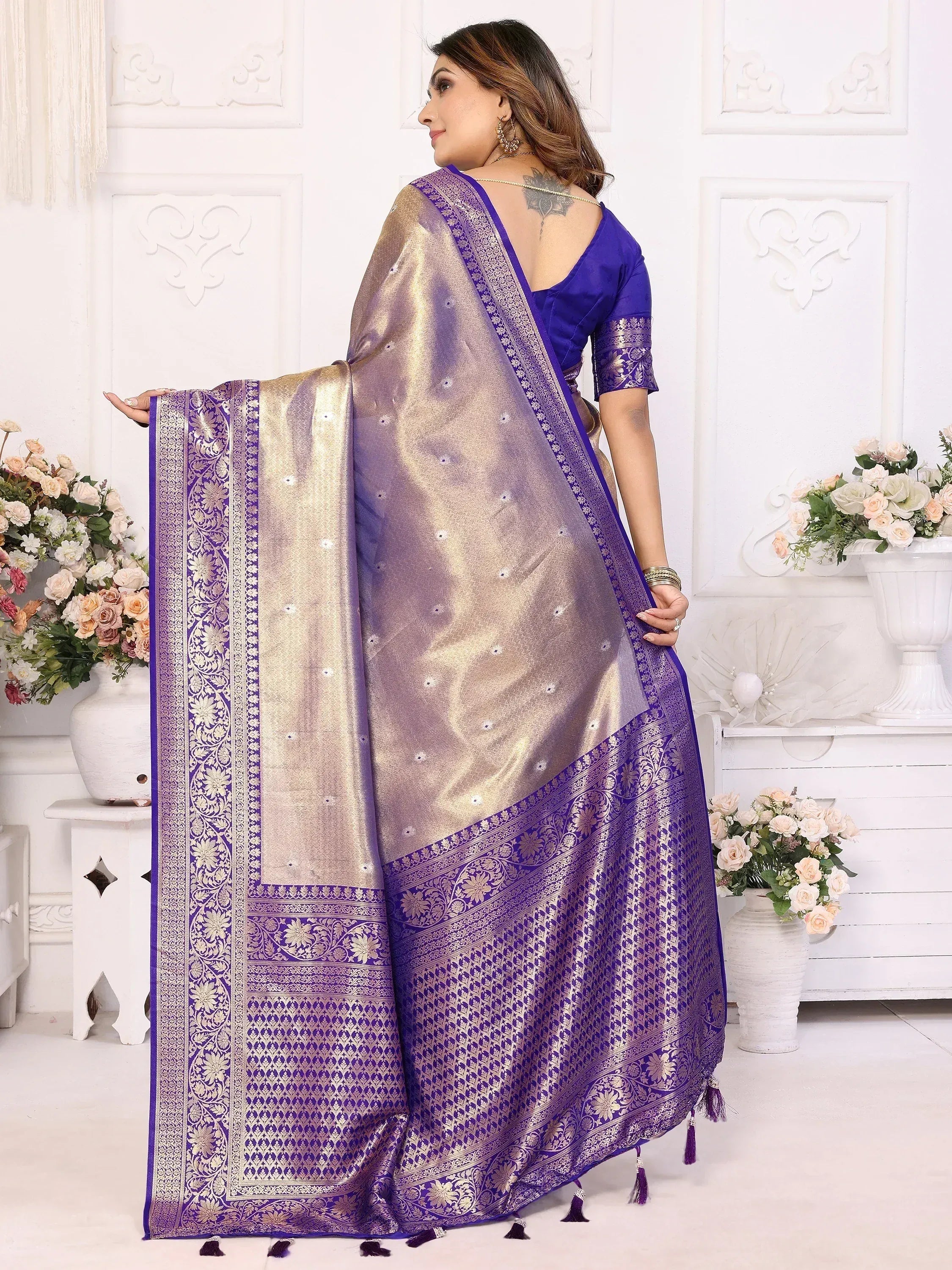 Purple and gold designer saree with intricate embroidery and tassels, perfect for ethnic occasions.