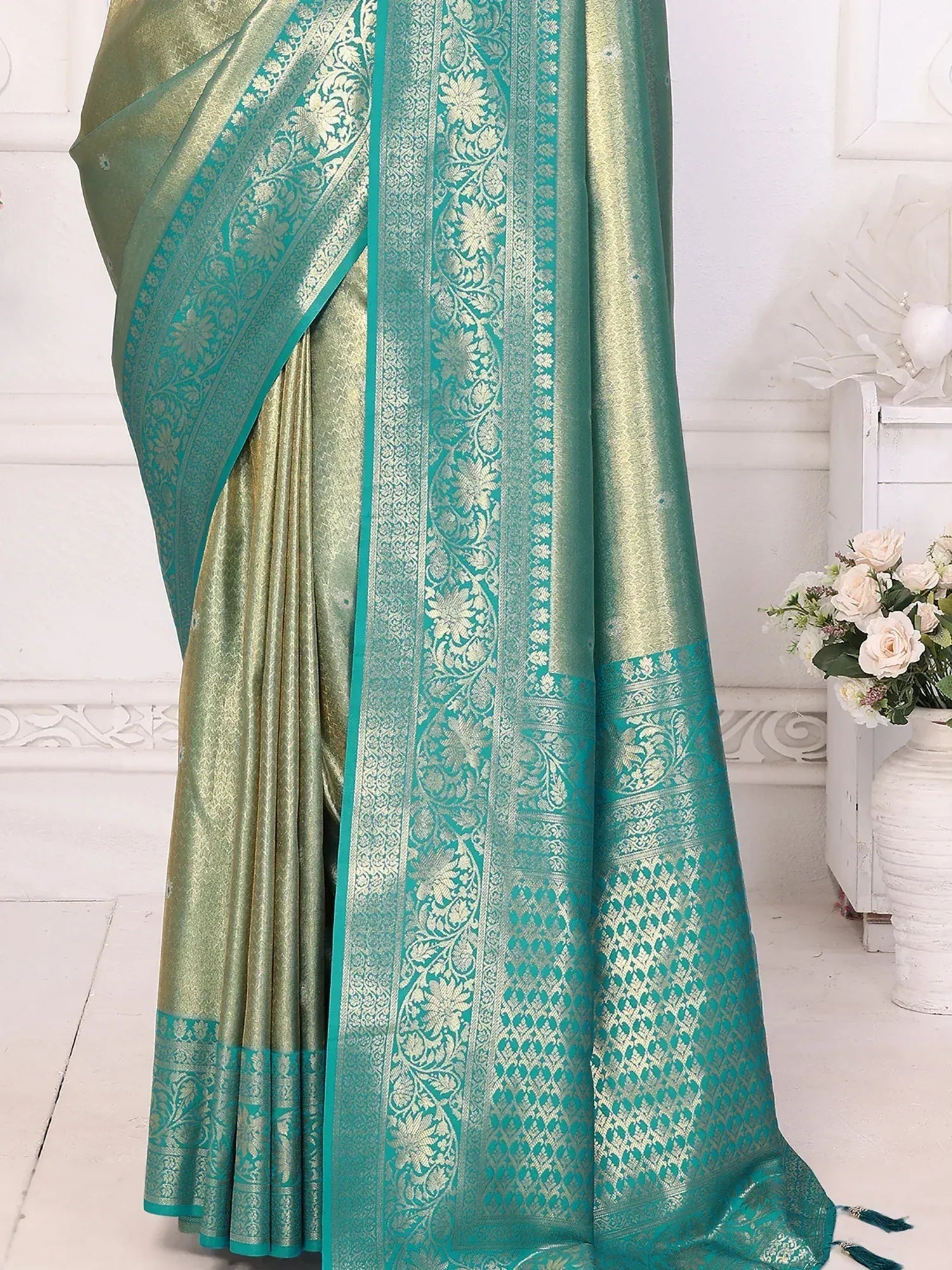 Elegant teal and gold ethnic saree with intricate floral zari work, perfect for Indian festive occasions.