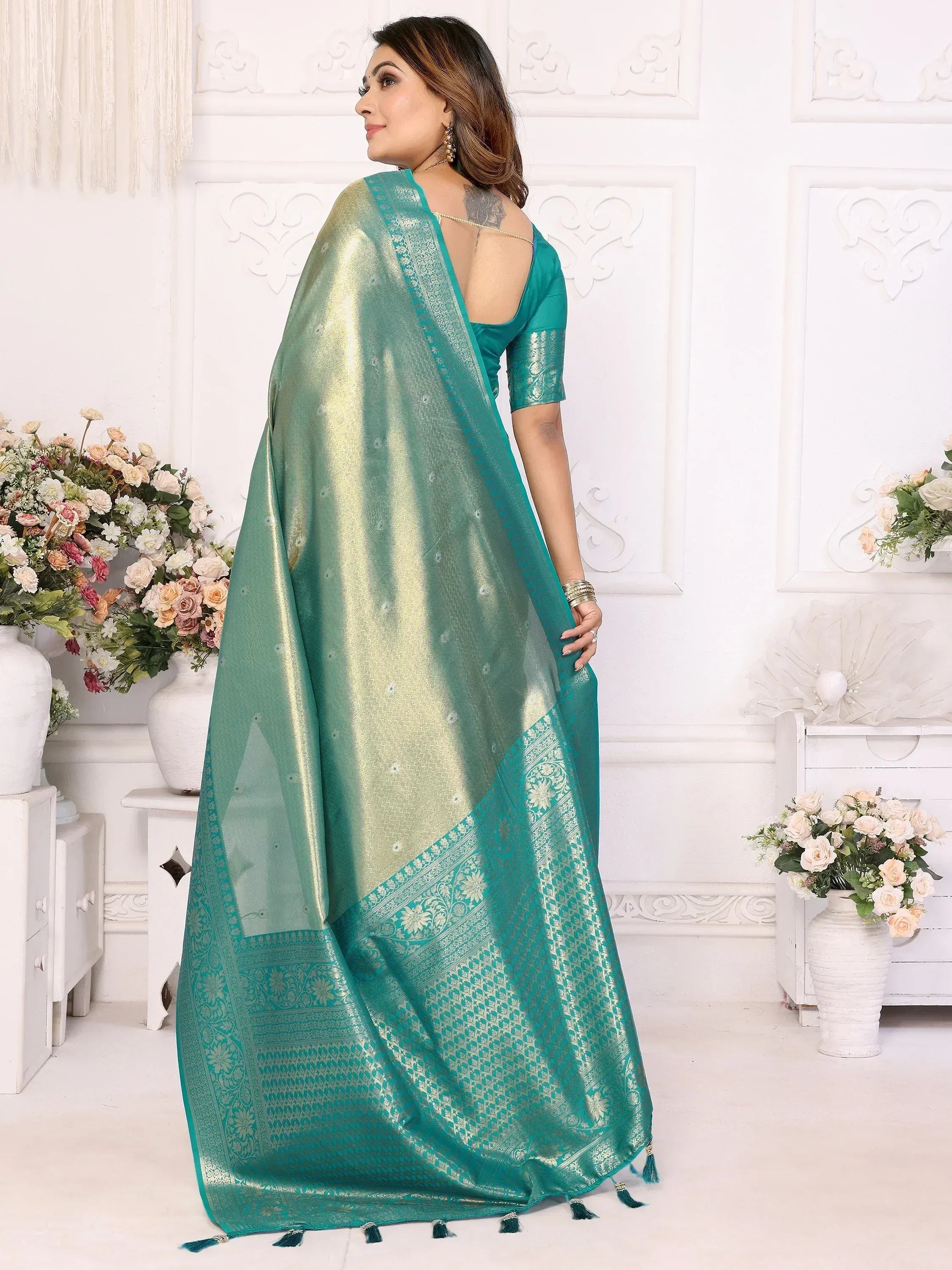 Teal designer saree with golden motifs and tassels, perfect for ethnic occasions