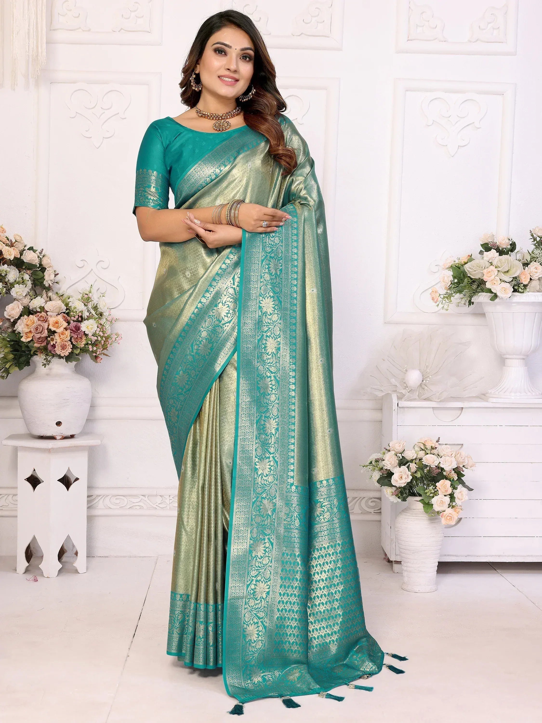 Elegant teal and gold designer saree with intricate floral border, perfect for ethnic occasions