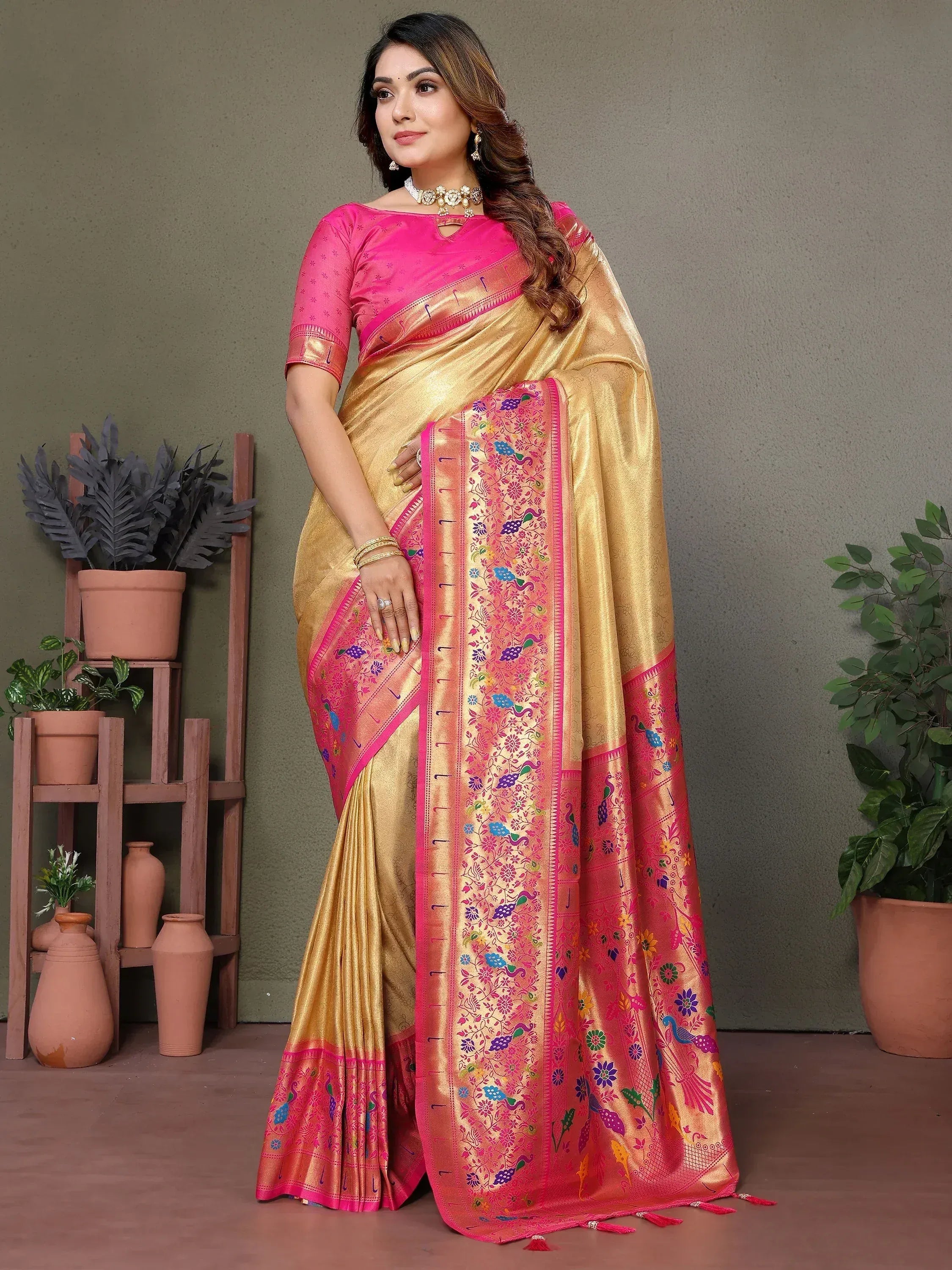 Elegant gold and pink saree with peacock embroidery, perfect for Indian ethnic wear occasions.