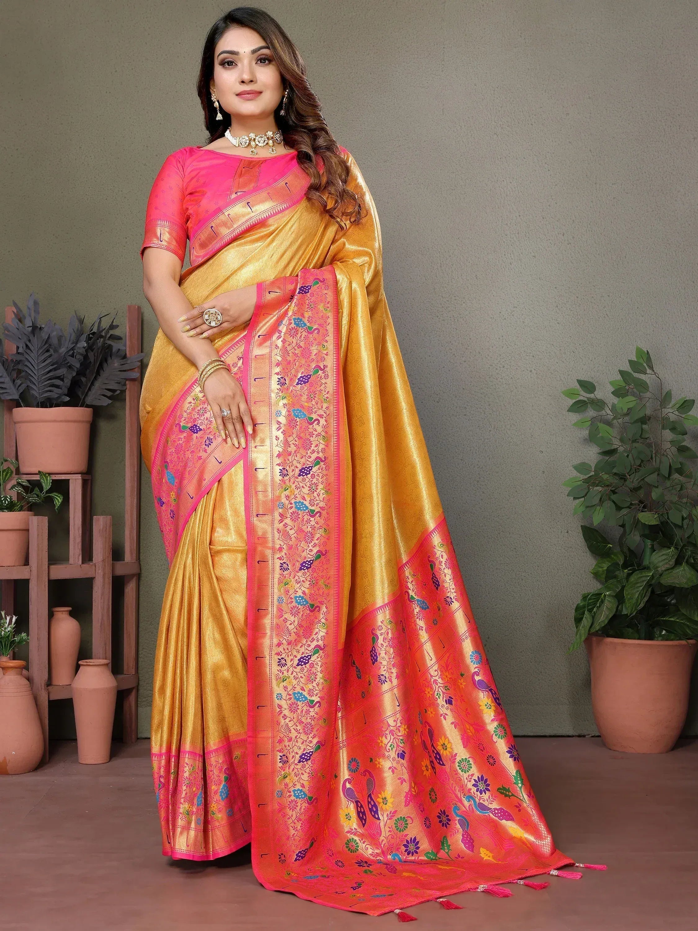 Golden saree with pink border and peacock embroidery, paired with matching blouse for festive occasions