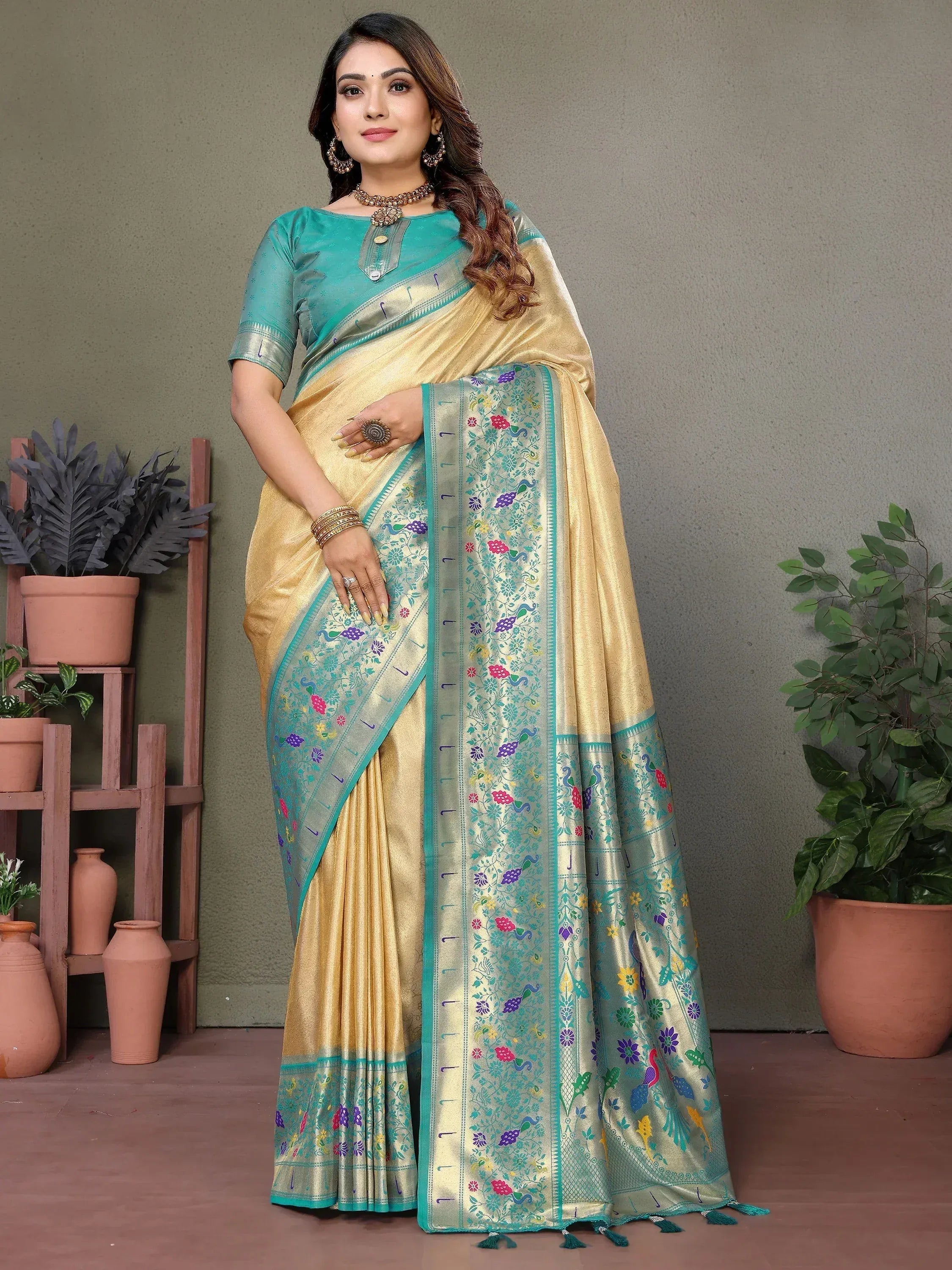 Elegant gold and teal saree with floral peacock border, perfect for Indian ethnic wear occasions.