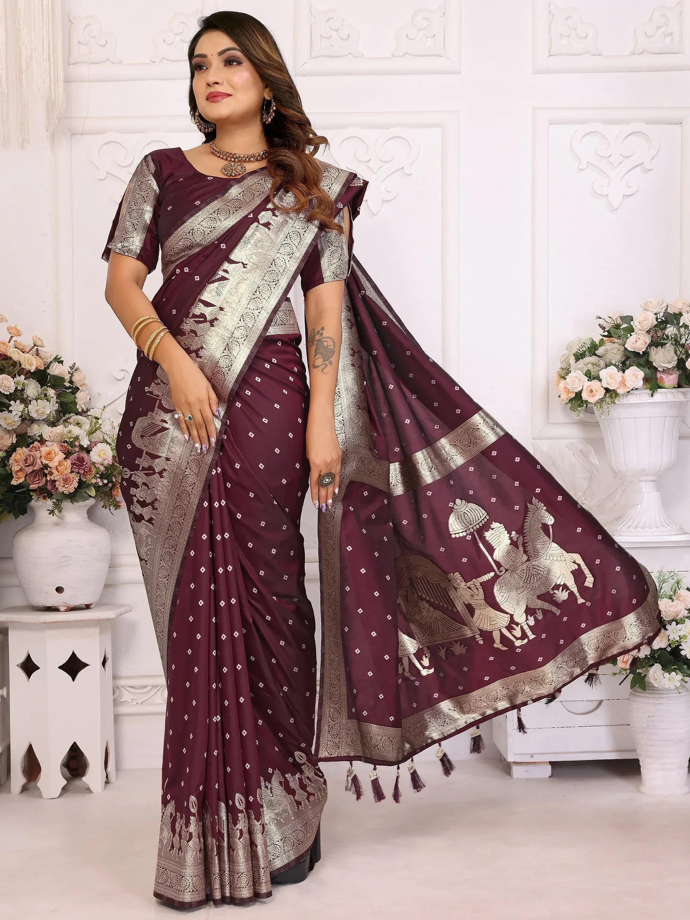 Elegant maroon saree with golden warrior & horse motifs, intricate border, and tassels for festive occasions