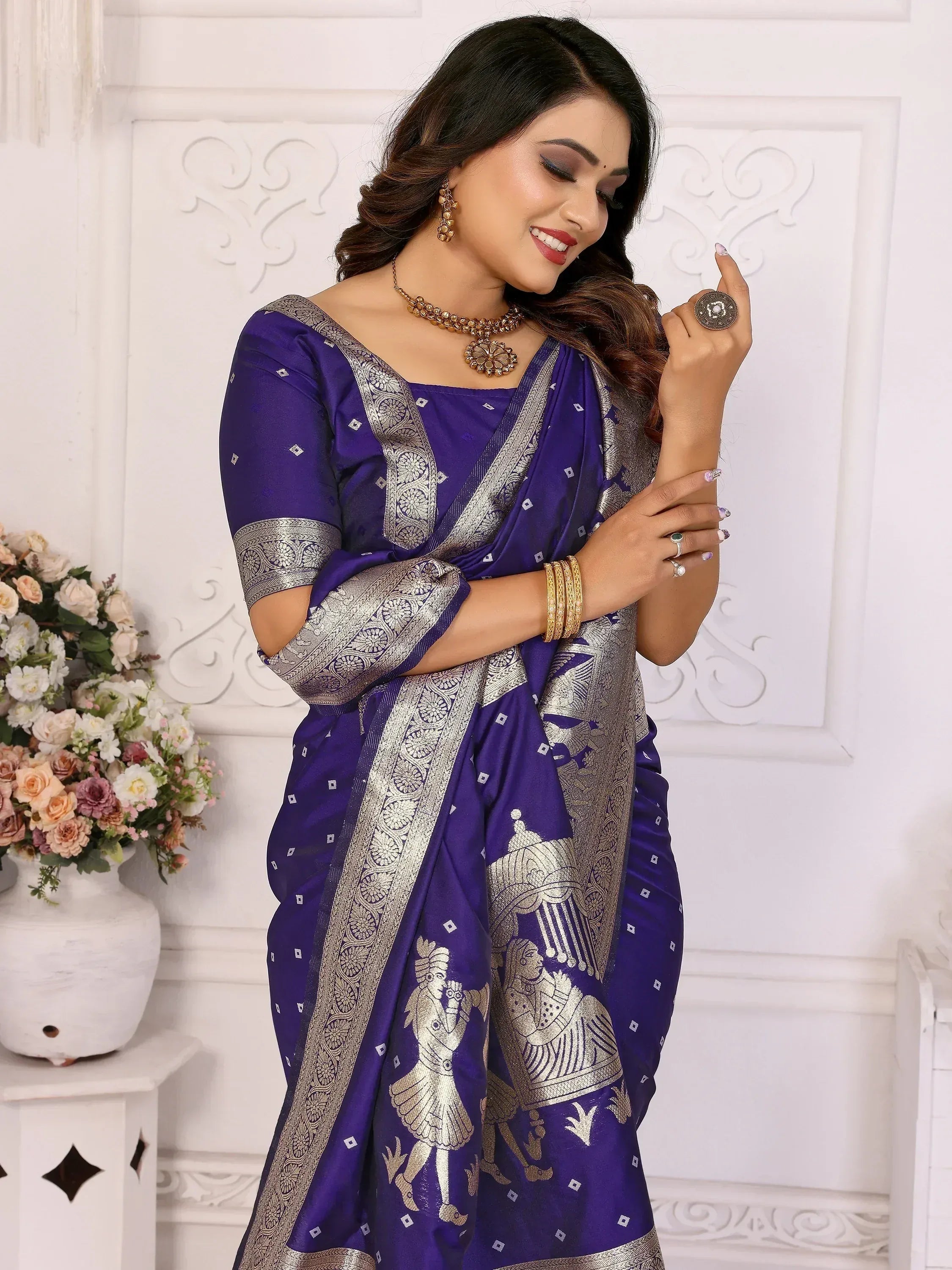 Purple saree with silver embroidery and traditional motifs, paired with gold jewelry for ethnic wear.
