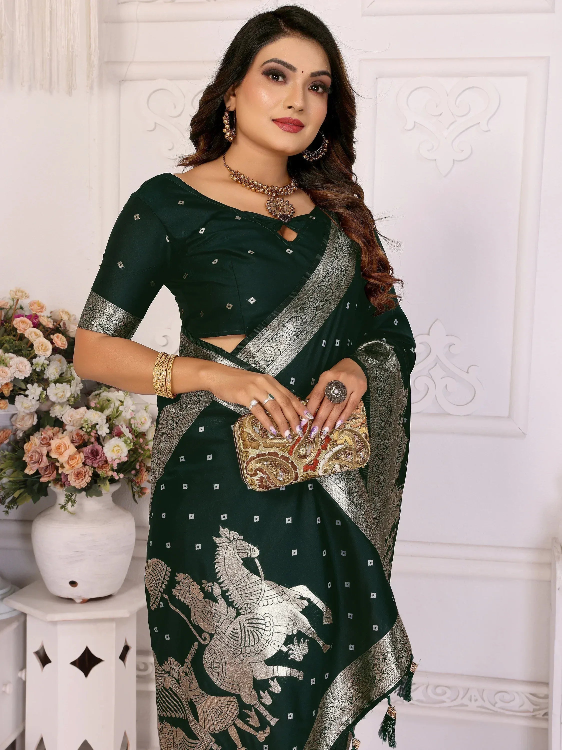 Elegant green saree with silver horse print and border, paired with matching blouse and clutch