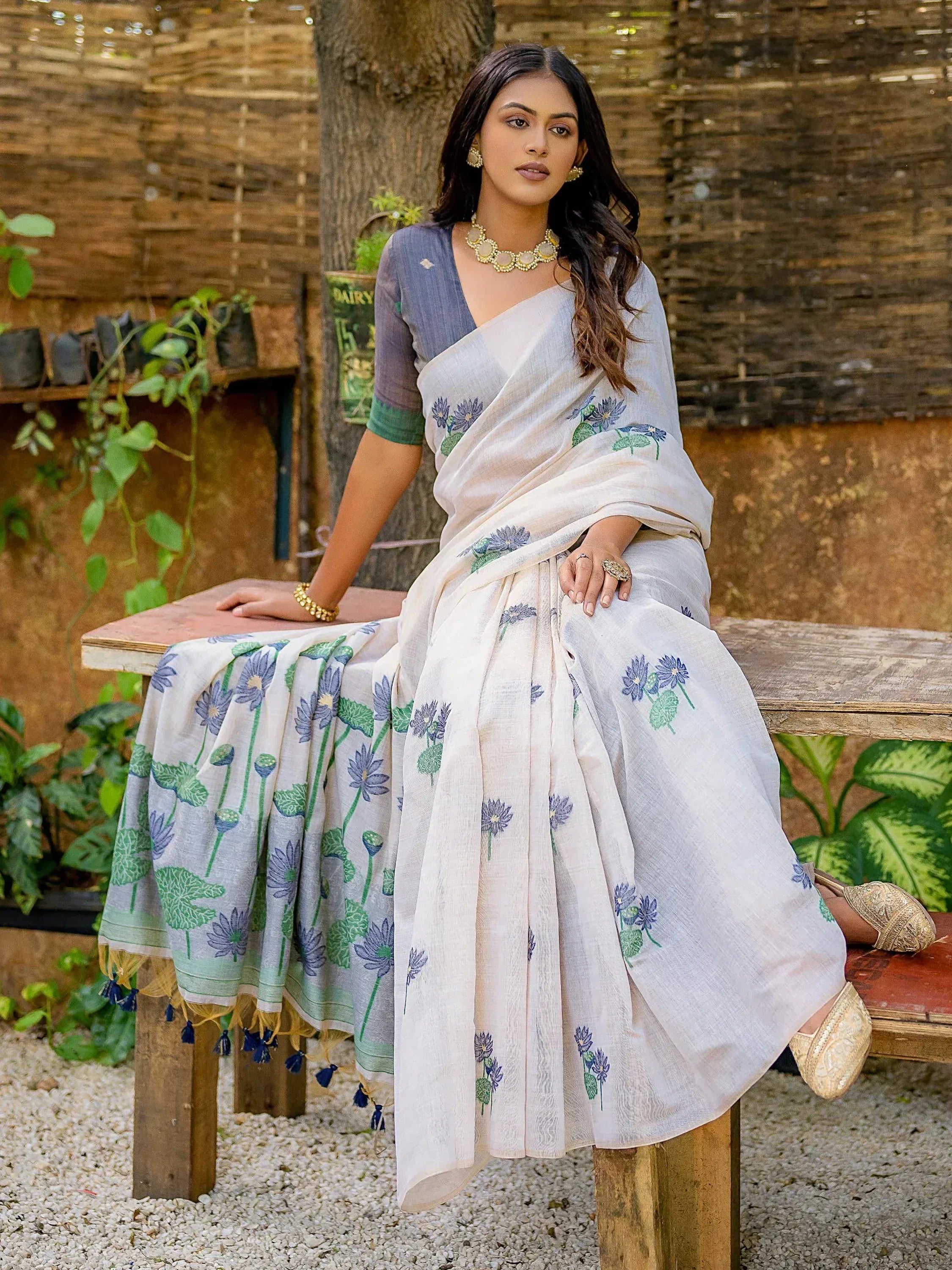 Elegant white saree with blue floral print, paired with a grey blouse, perfect for ethnic occasions.