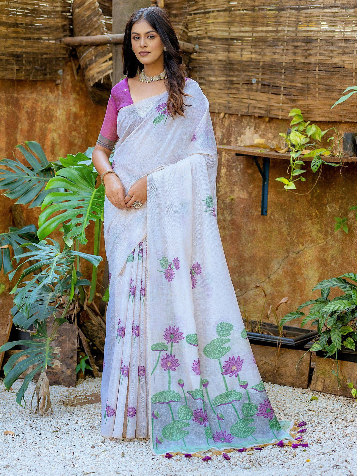 White saree with purple floral print, paired with pink blouse, ideal for ethnic occasions