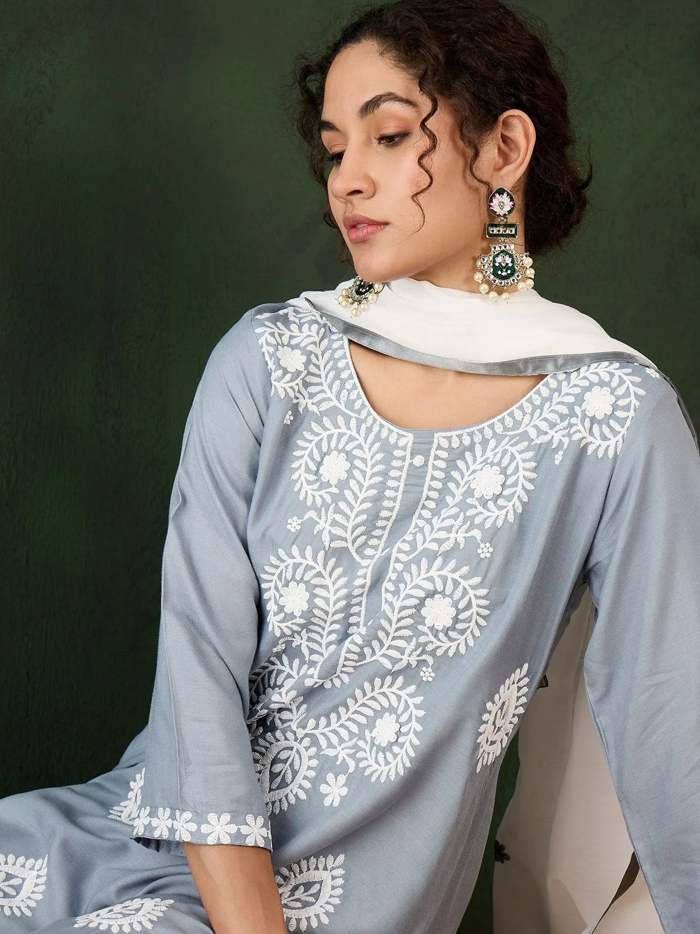 Grey embroidered salwar kameez with white floral work and matching dupatta, styled with statement earrings.