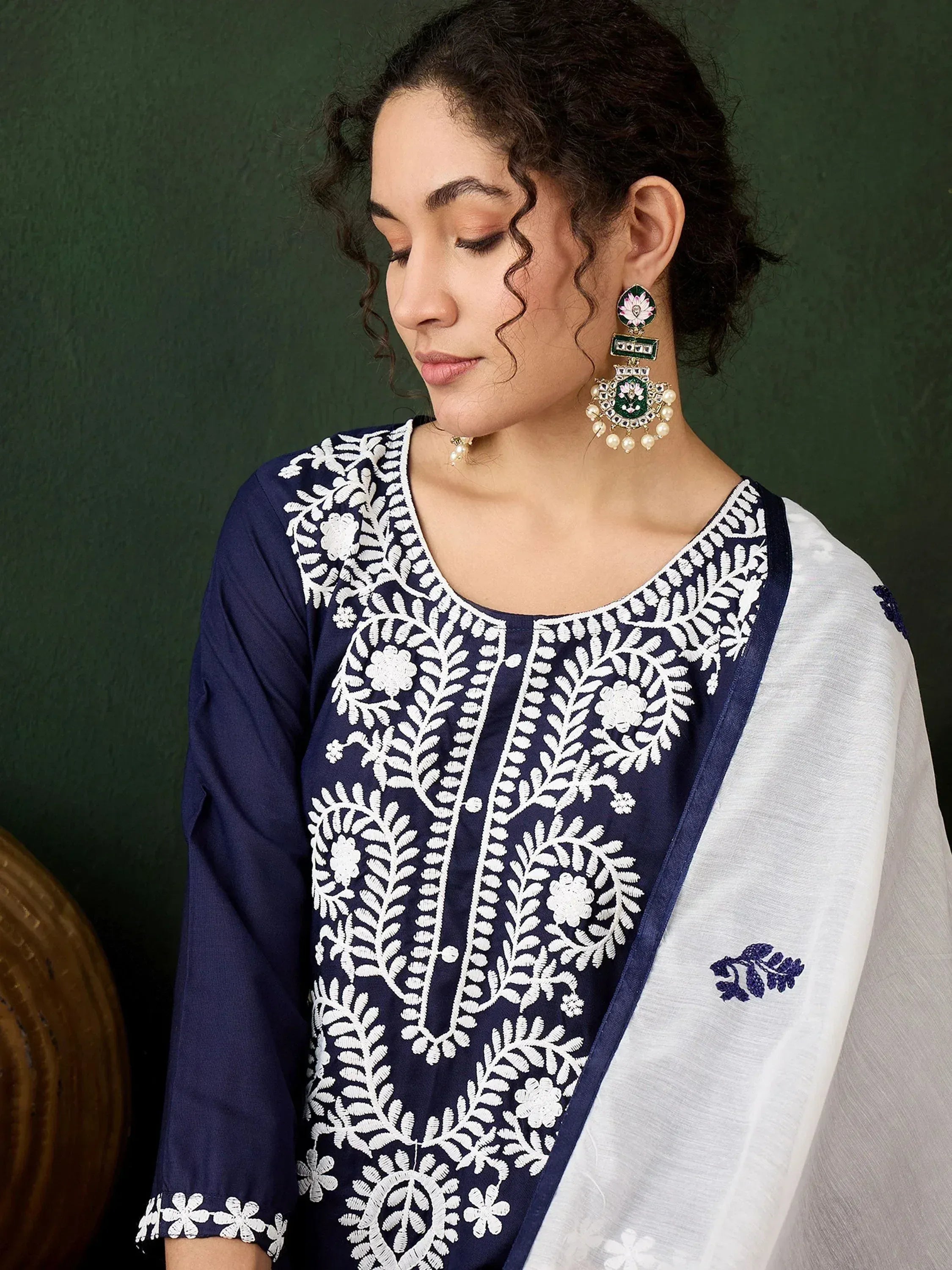 Navy blue and white embroidered salwar kameez with floral detailing and matching dupatta, styled with traditional earrings.