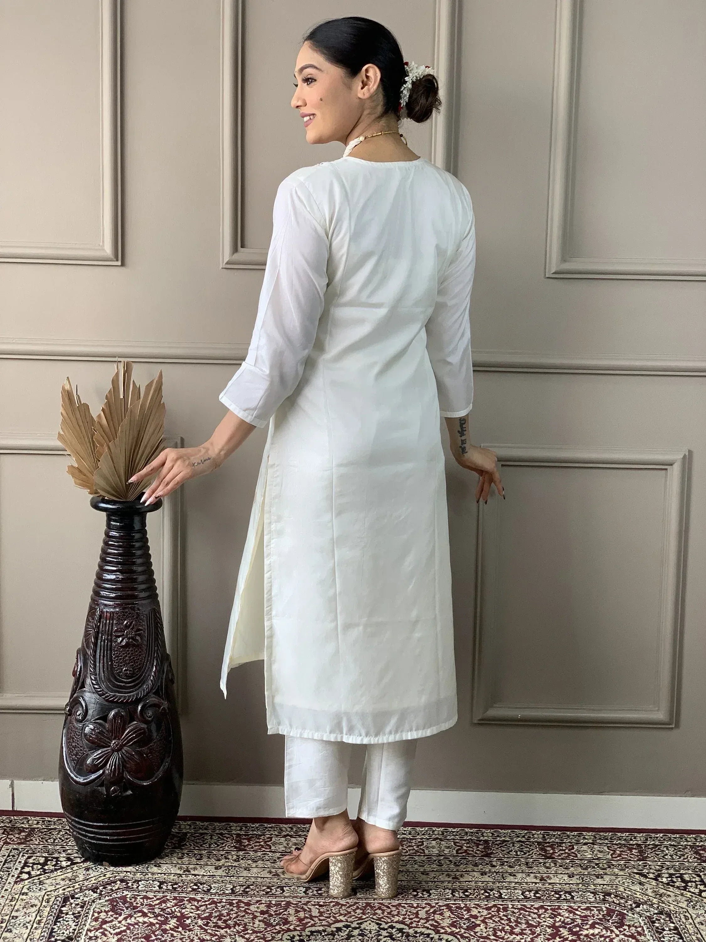 White ethnic kurta with side slits paired with matching pants, styled for modern Indian wear