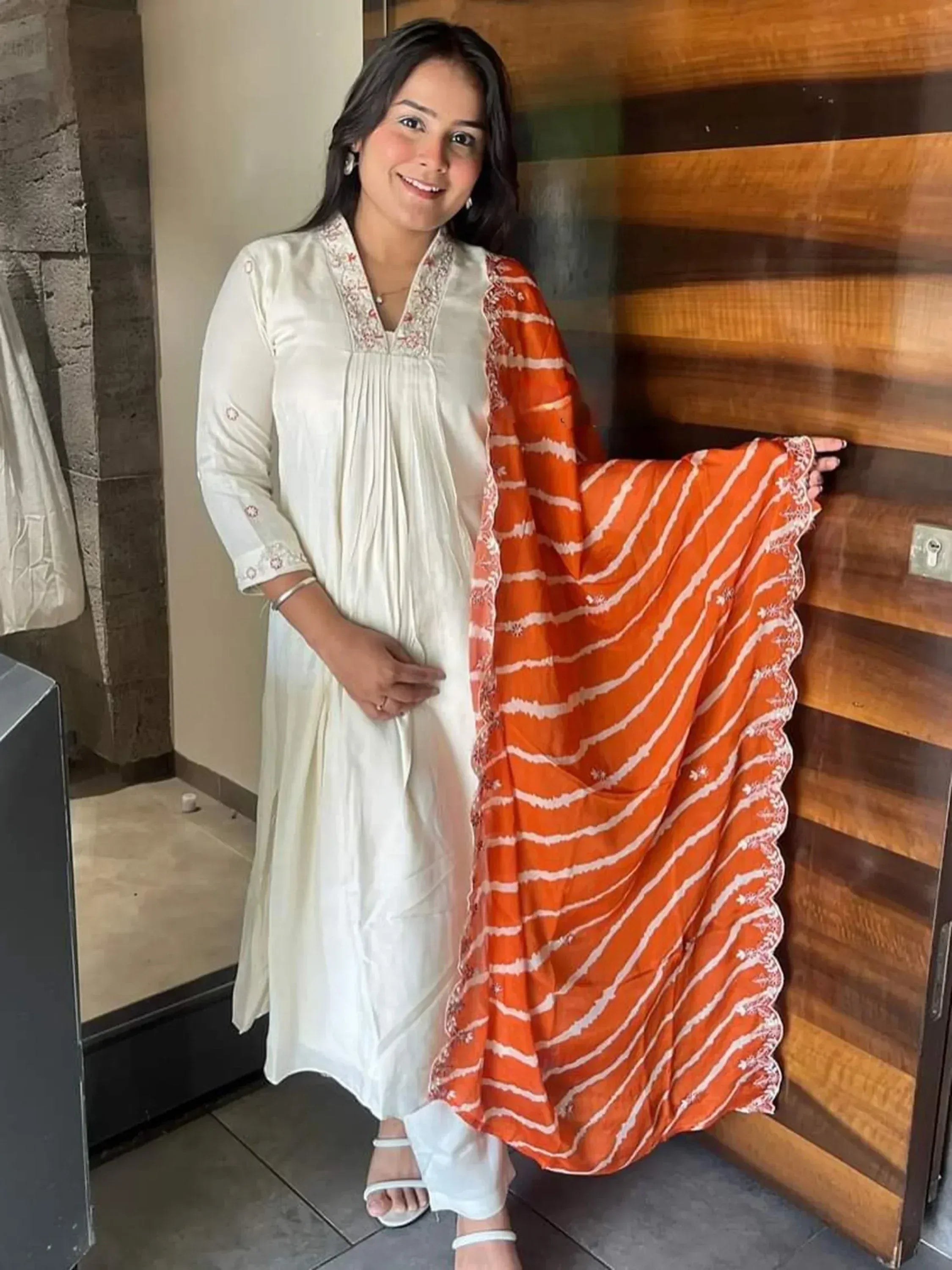 Woman in white embroidered kurta with orange striped dupatta, Indian ethnic wear