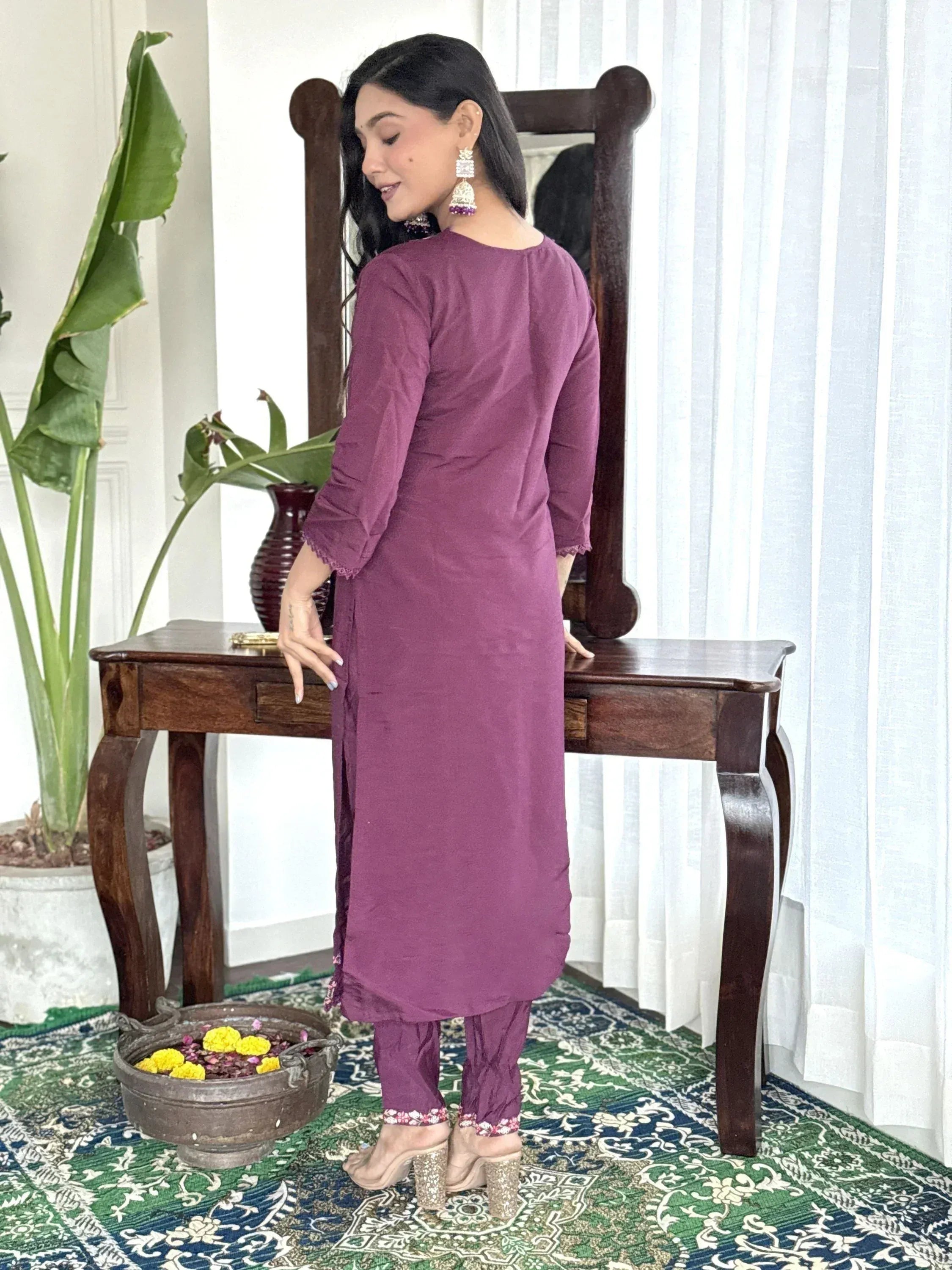 Purple ethnic kurta with matching pants, floral hem detail, and statement earrings for Indian wear