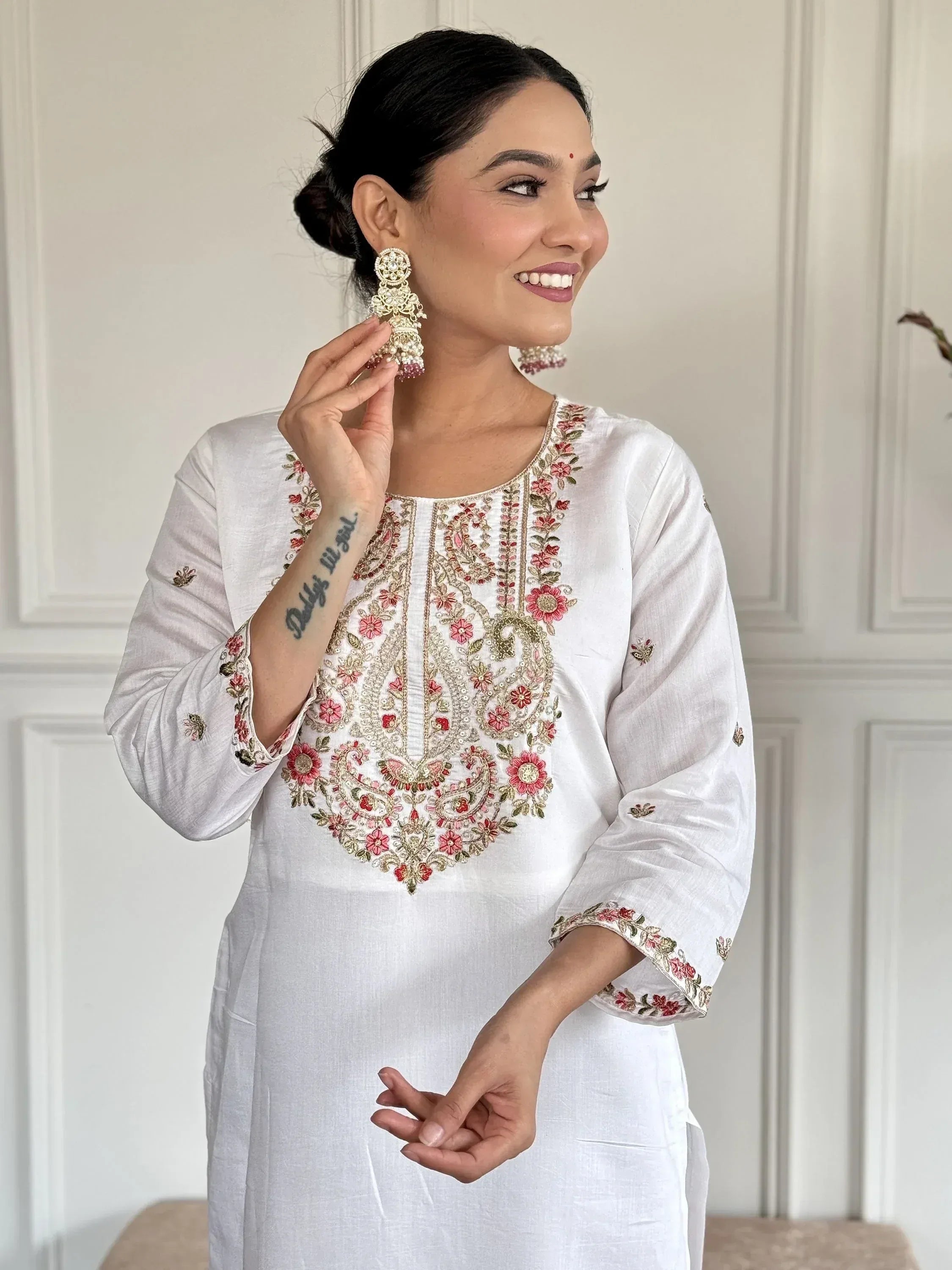 White embroidered kurta with floral design, paired with jhumka earrings for Indian ethnic wear