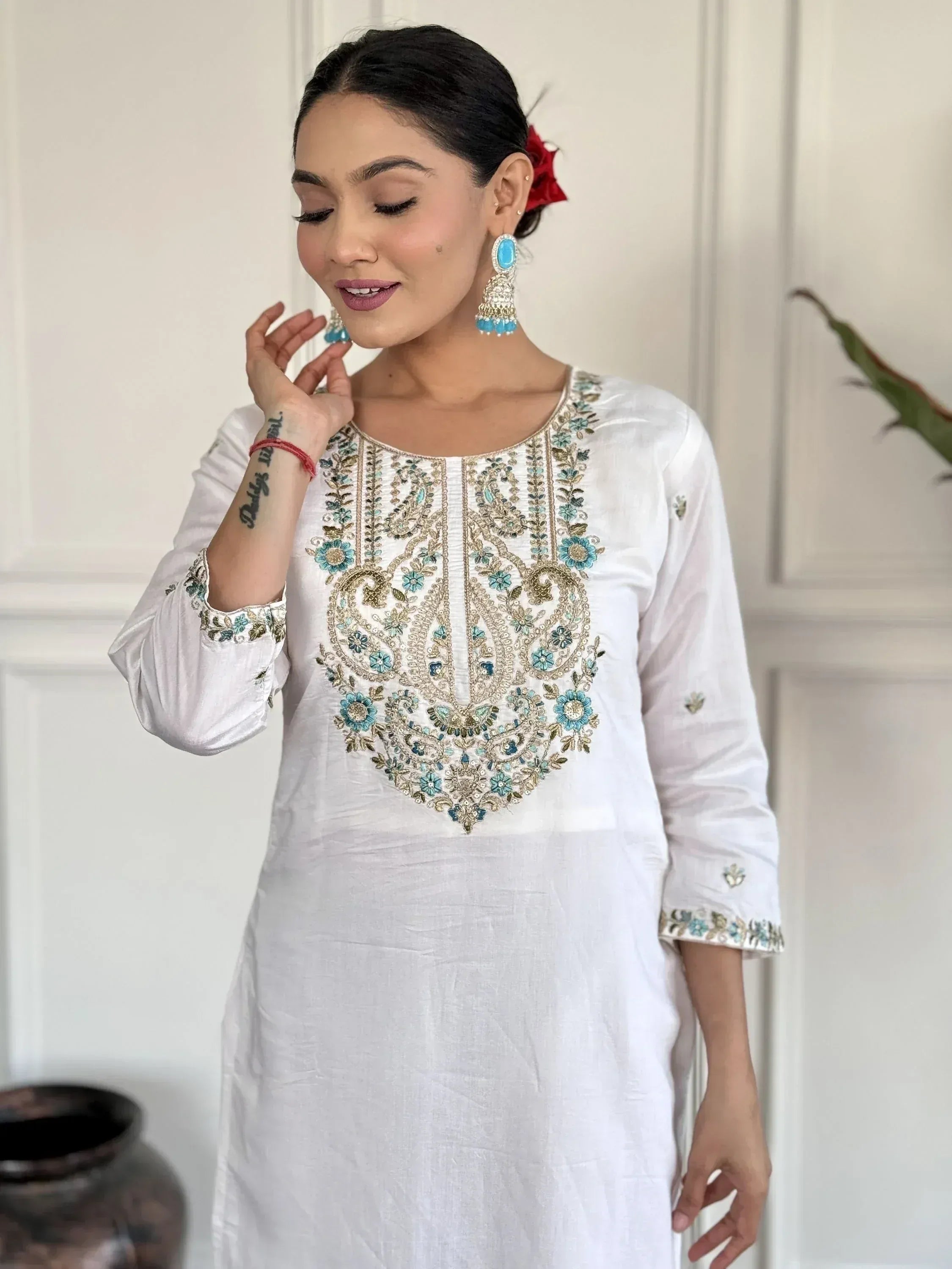 White embroidered kurta with blue floral detailing, paired with statement earrings for ethnic wear