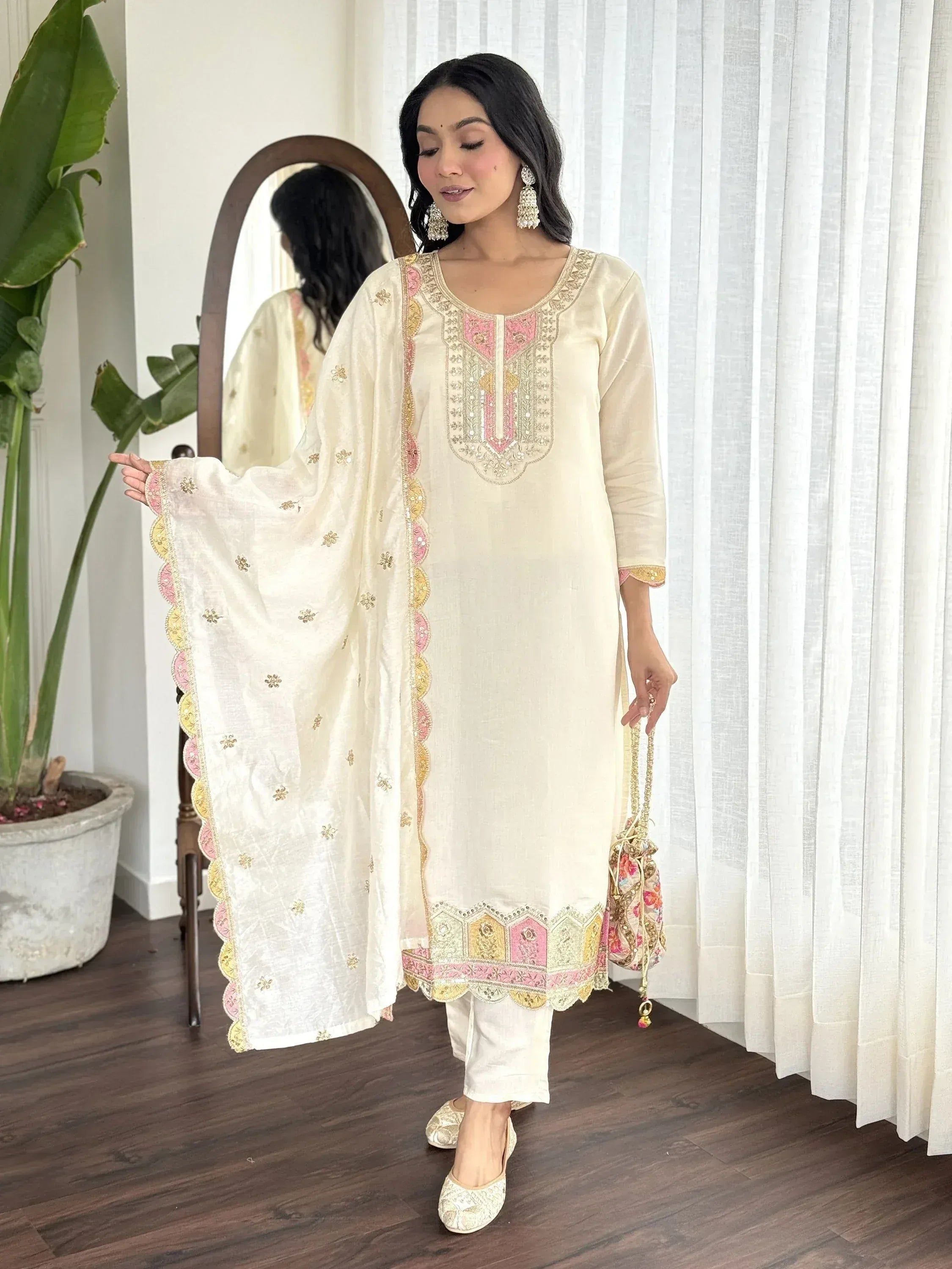 Cream embroidered salwar kameez with pink and gold detailing, paired with matching dupatta and jutis