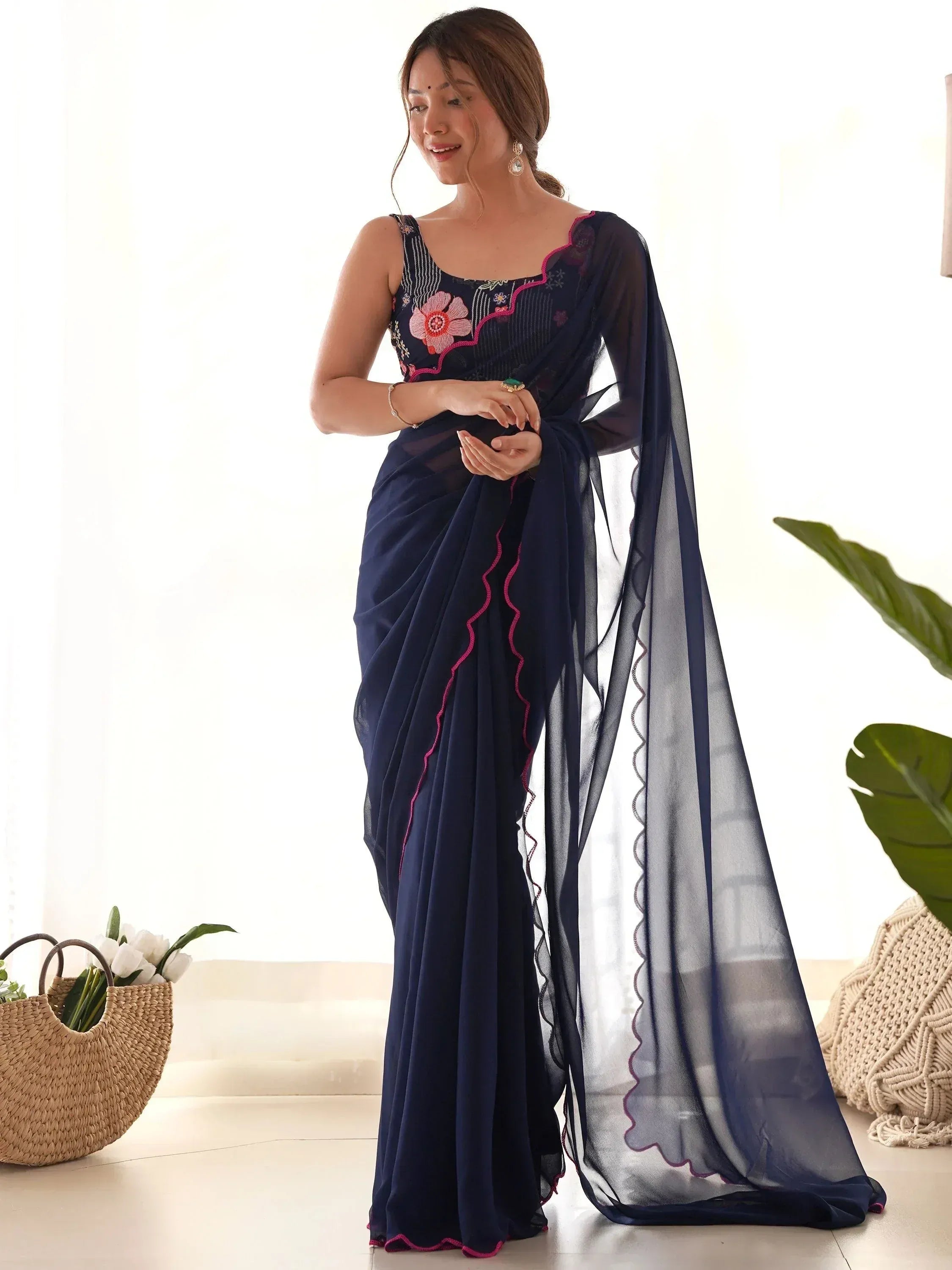 Navy blue embroidered saree with pink floral detailing and sheer dupatta, styled for Indian ethnic wear
