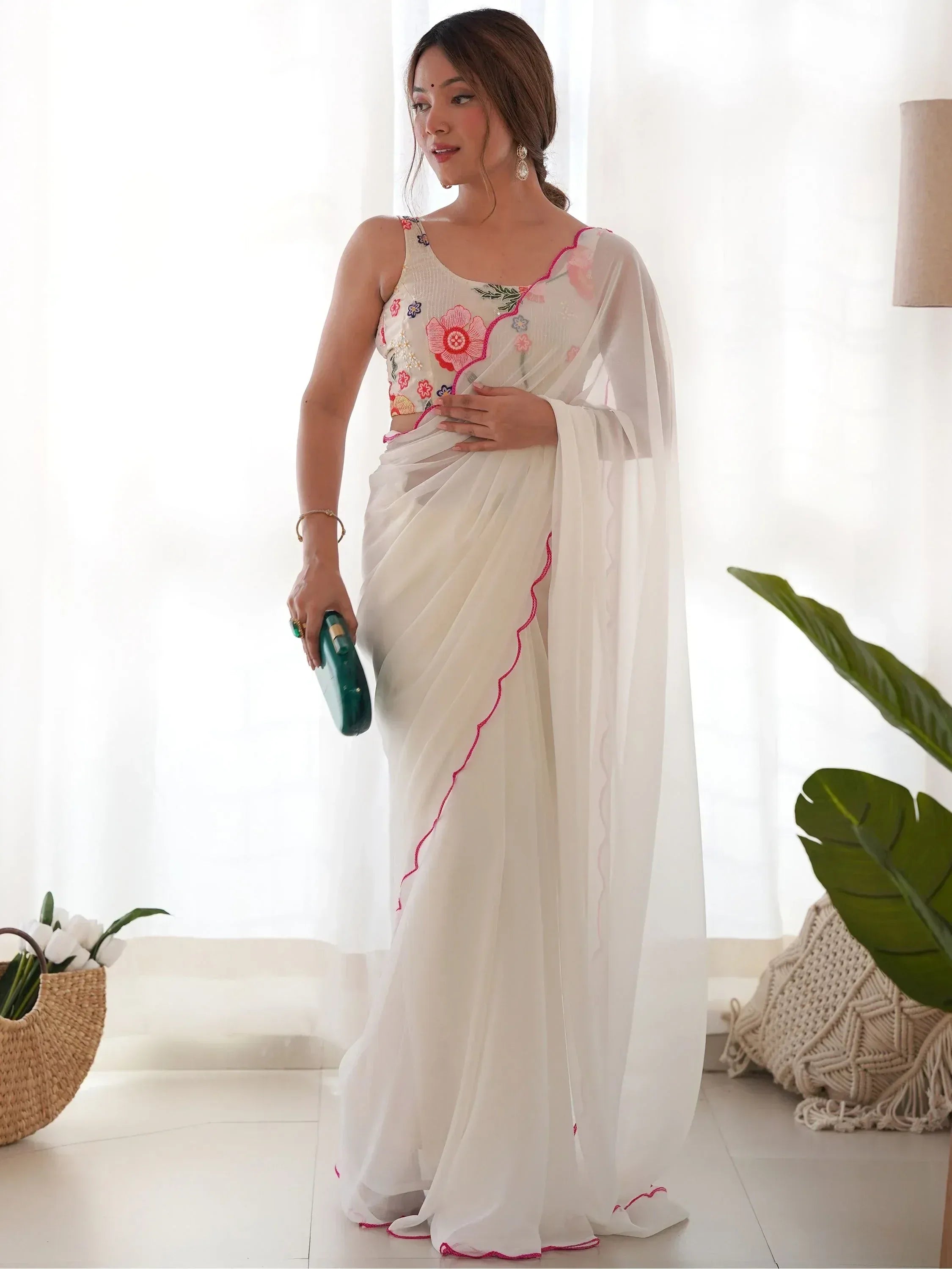 White saree with floral embroidery and pink trim, paired with a matching blouse, ideal for Indian ethnic wear occasions.