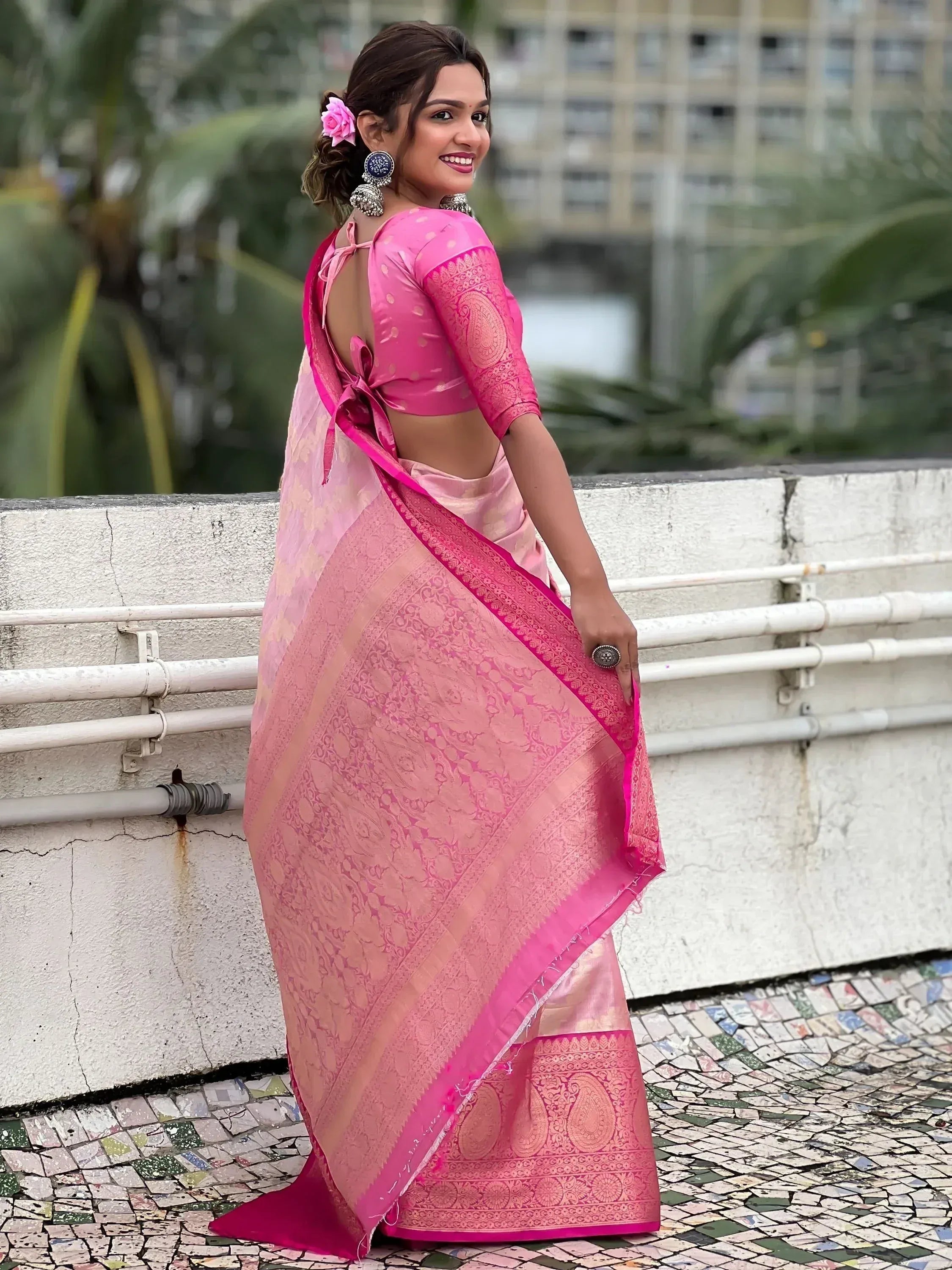 Pink designer saree with floral border and back-tie blouse, perfect for Indian ethnic wear occasions