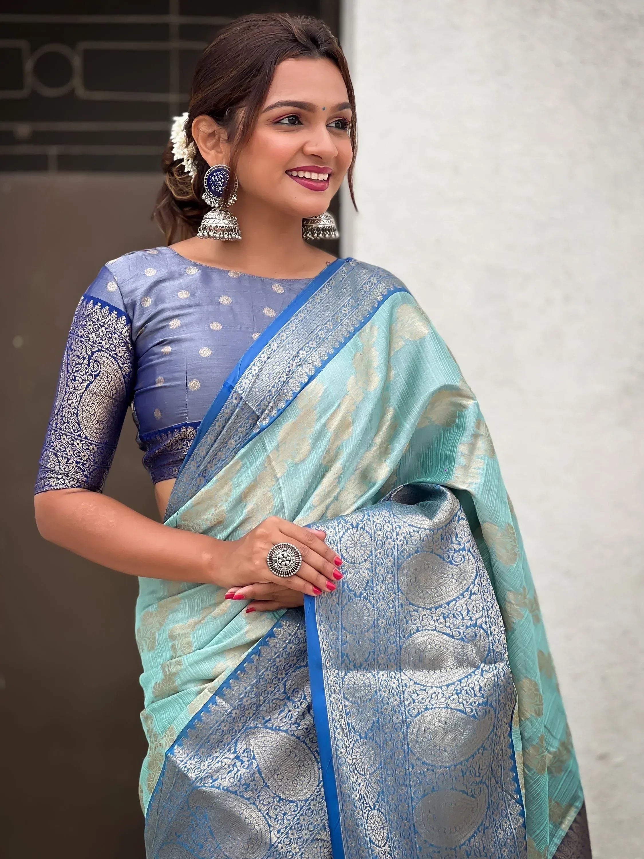 Woman in elegant blue and mint designer saree with gold paisley print, perfect for Indian ethnic wear occasions.