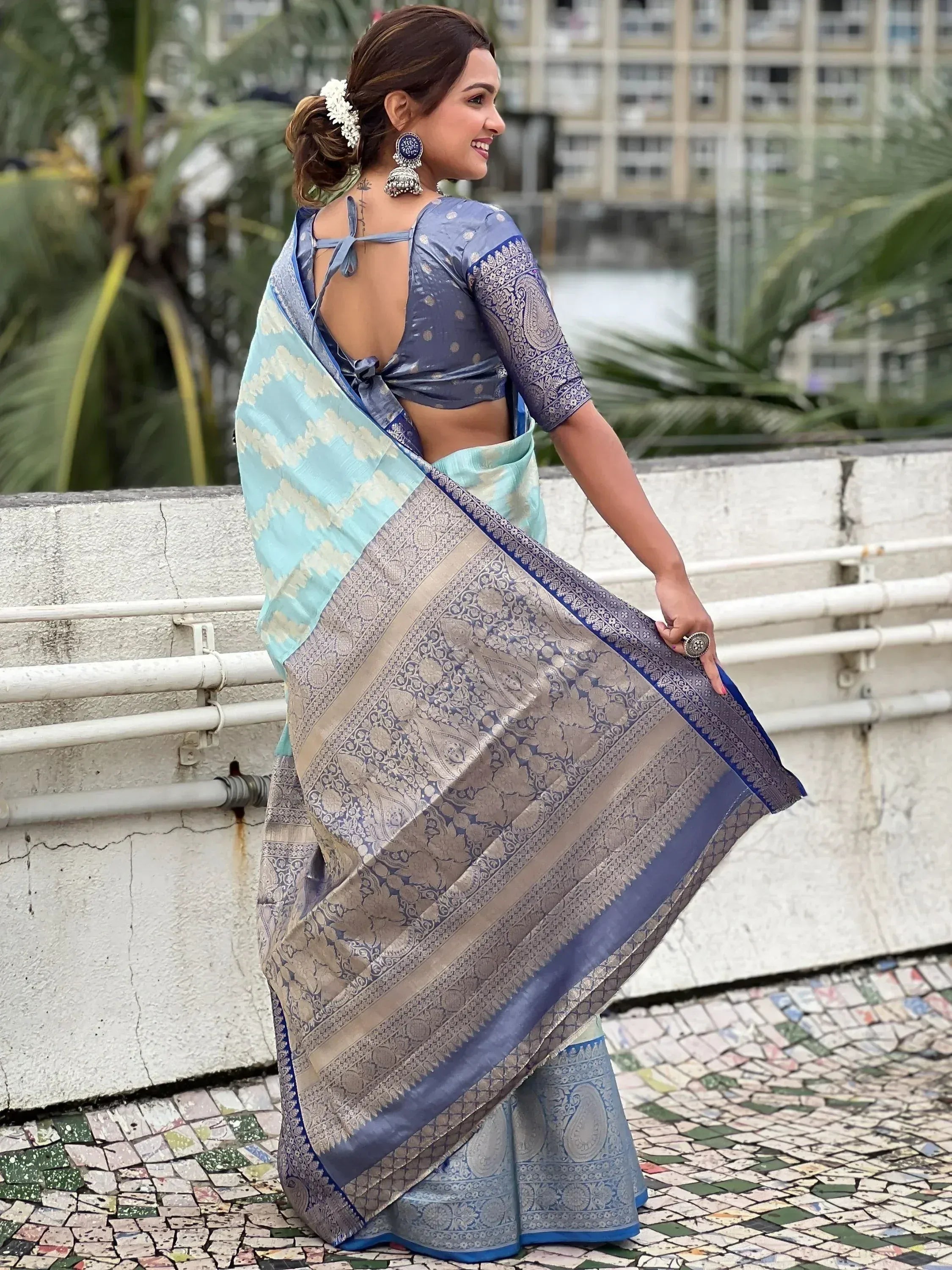 Blue and silver designer saree with intricate paisley patterns, paired with a back-tie blouse, perfect for ethnic occasions.
