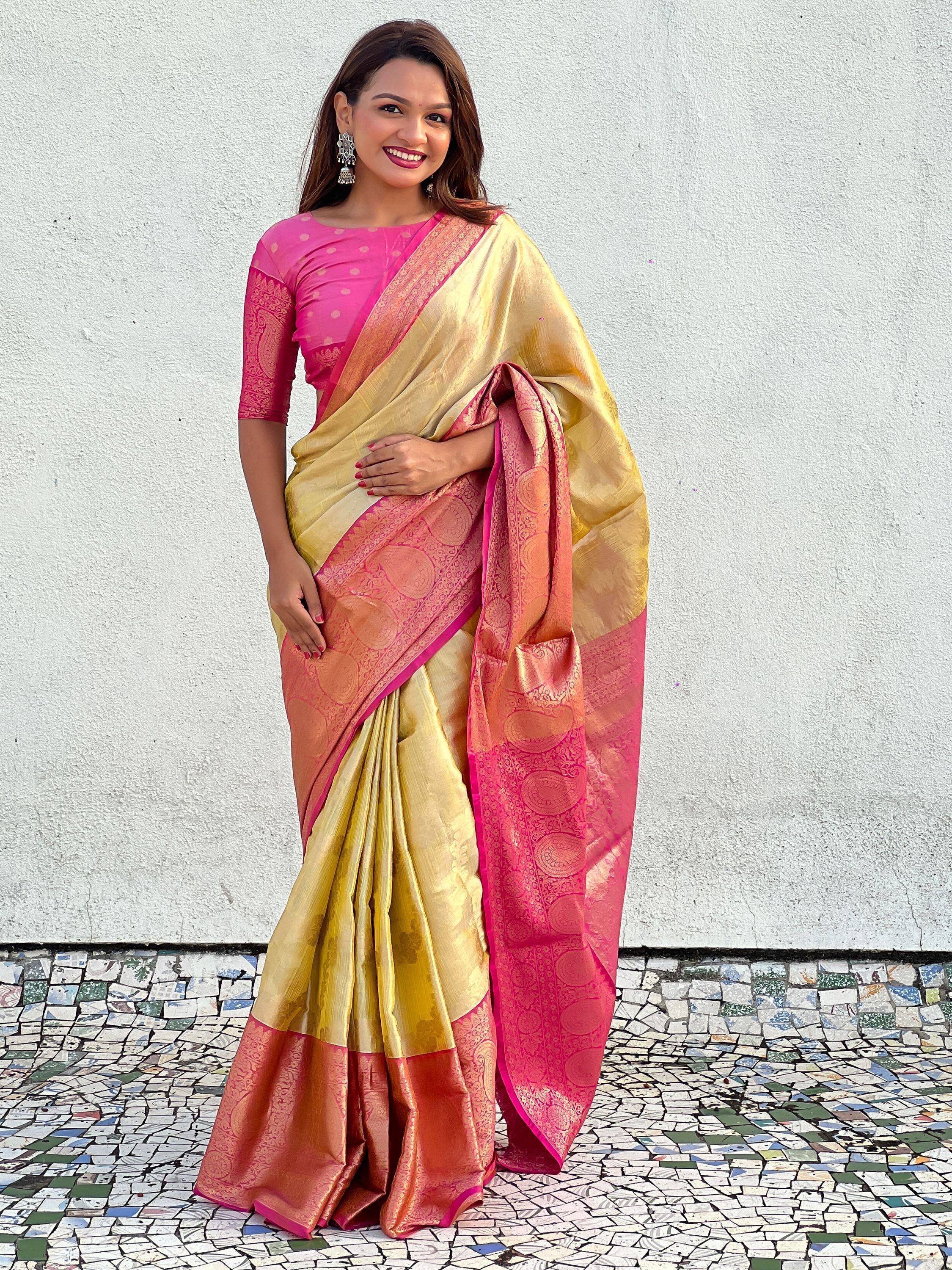 Woman in elegant gold and pink designer saree with intricate paisley border, perfect for Indian ethnic occasions