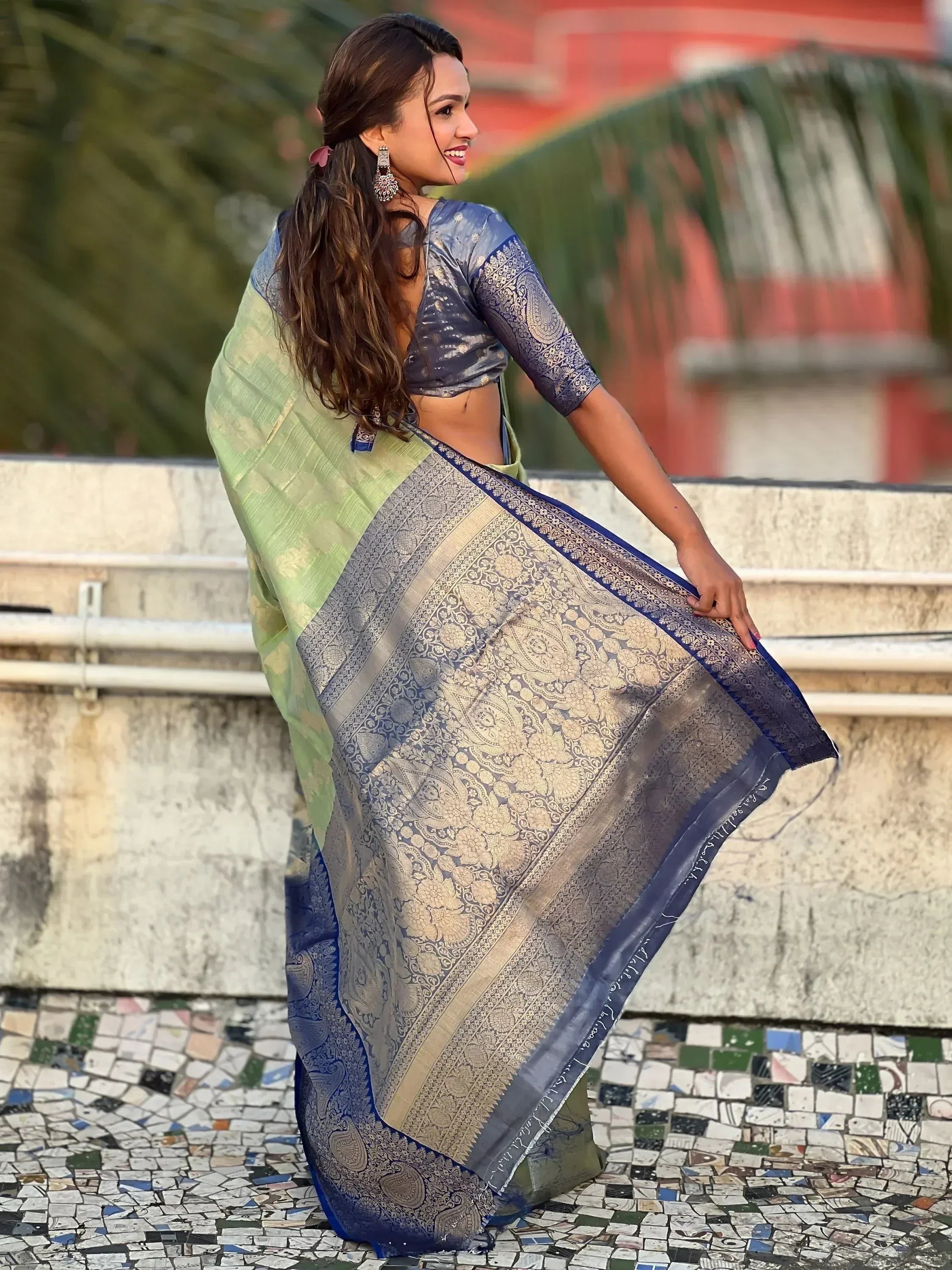 Woman in elegant blue and green designer saree with gold paisley print, perfect for Indian ethnic wear occasions.
