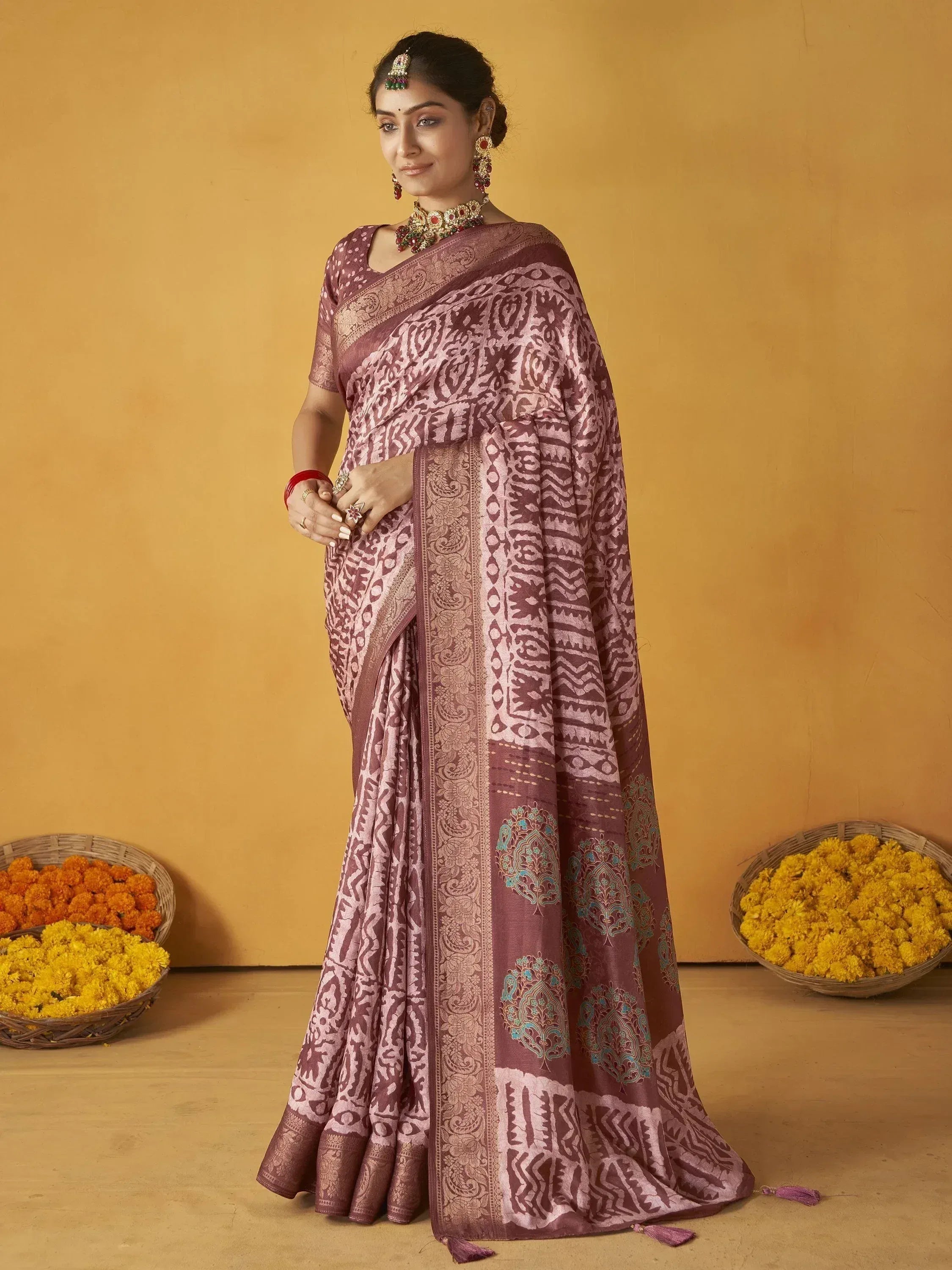 Woman in maroon printed saree with gold border, traditional Indian ethnic wear, floral baskets backdrop