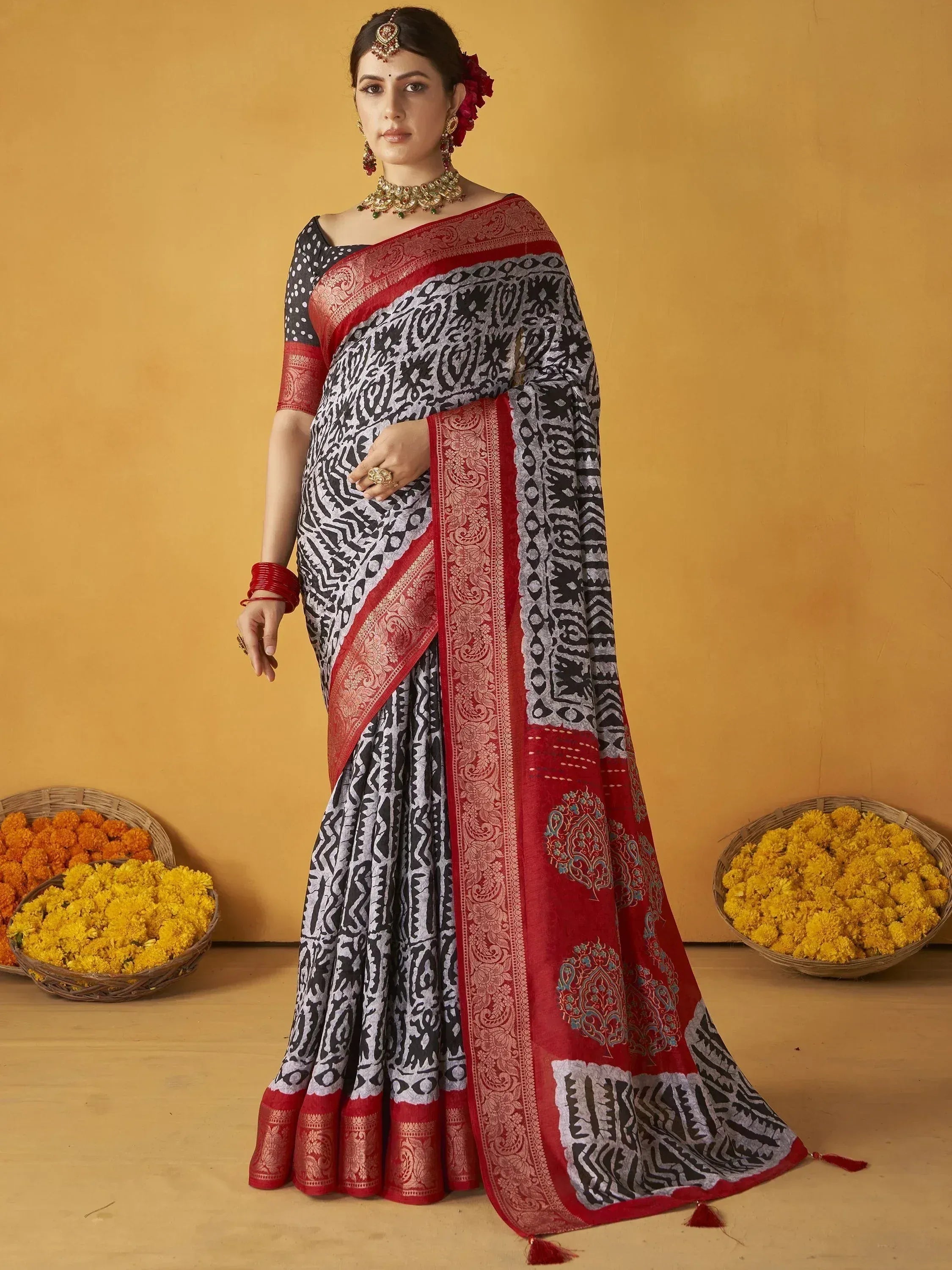 Woman in black and red printed saree with gold jewelry, traditional Indian ethnic wear