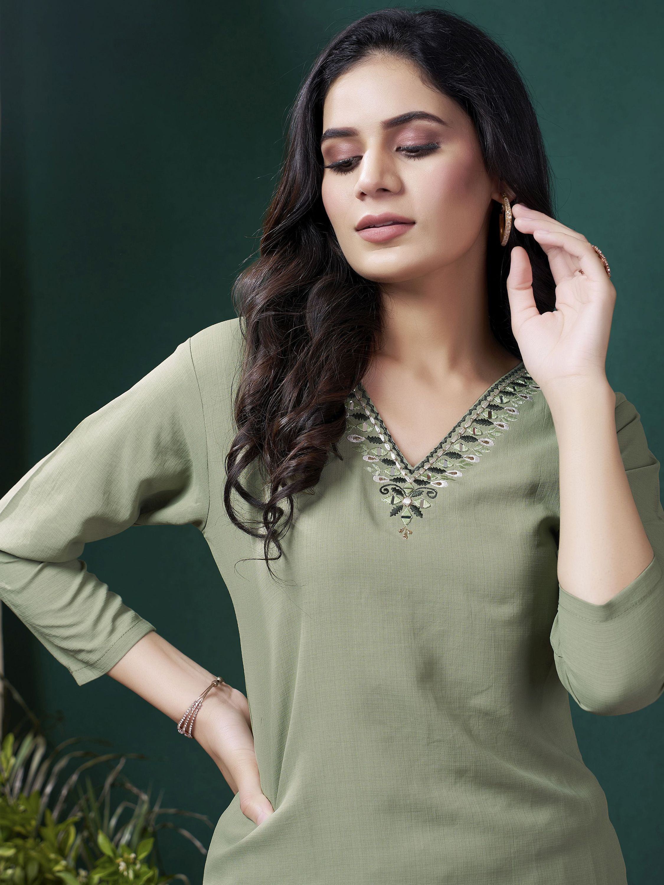 Woman in olive green embroidered kurti with V-neck and three-quarter sleeves