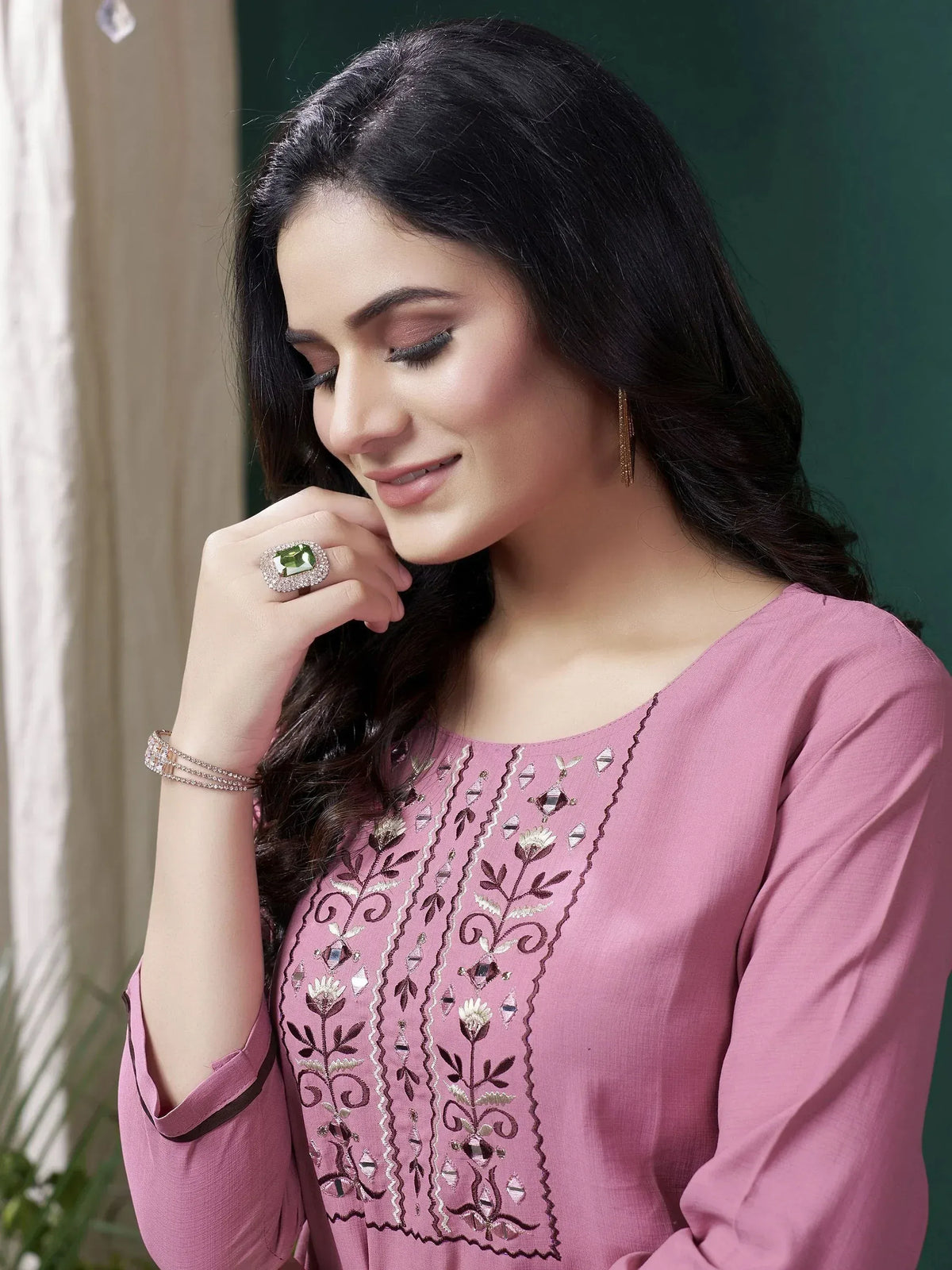 Pink embroidered ethnic kurti with floral detailing and mirror work, styled with statement ring and earrings
