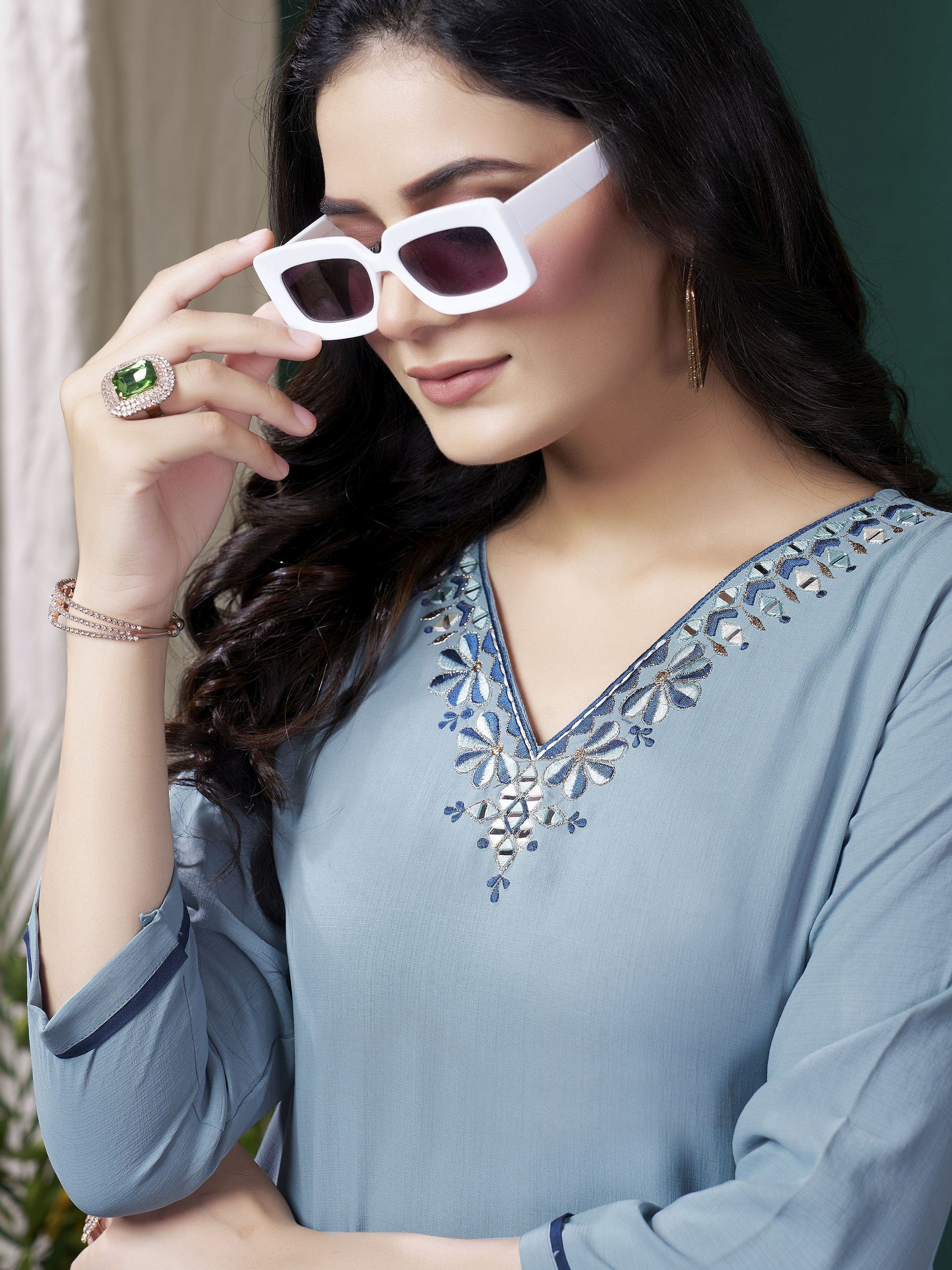Woman in light blue embroidered kurti with white sunglasses and statement ring
