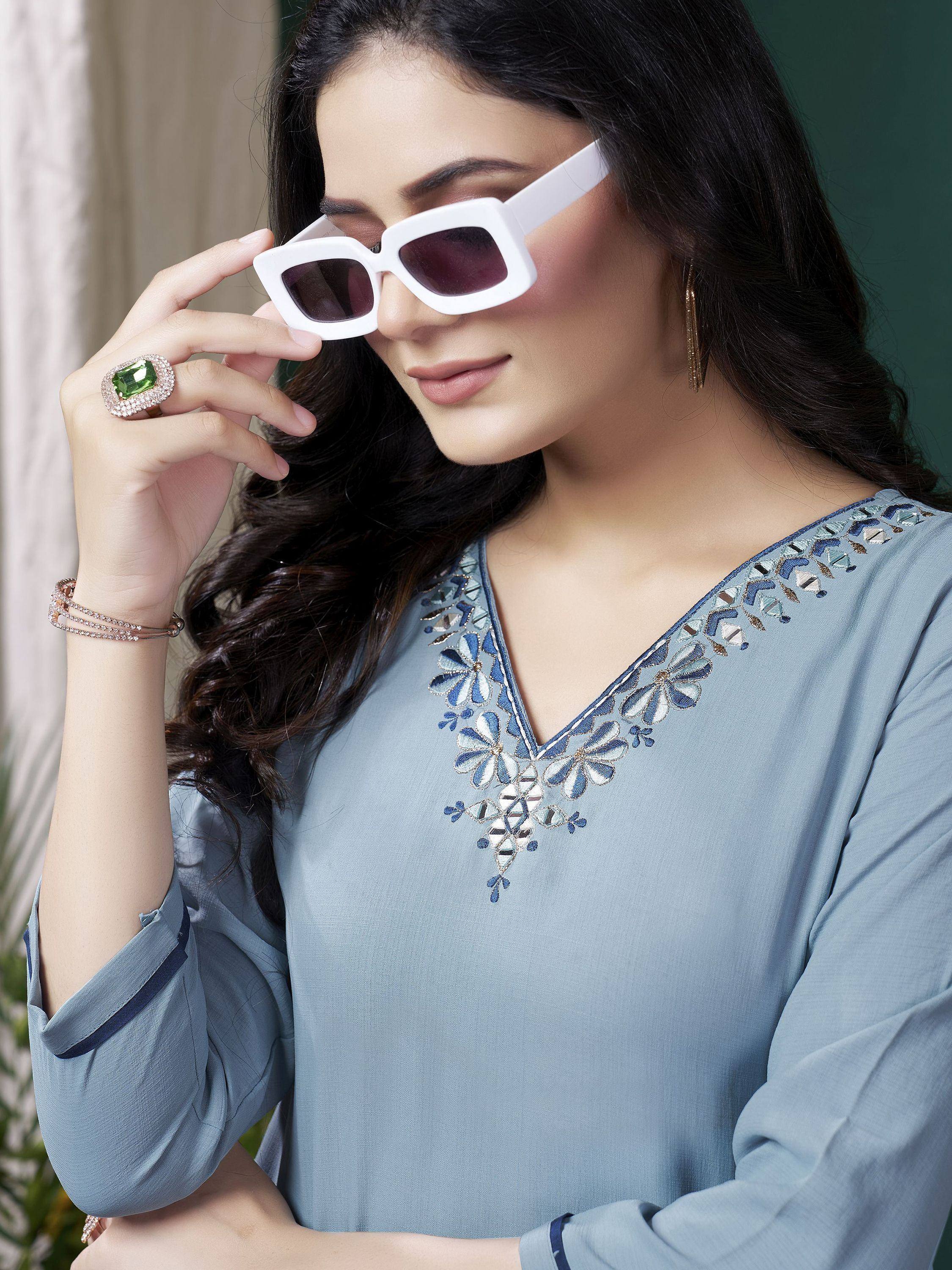Stylish woman in blue embroidered ethnic kurti with white sunglasses and green ring