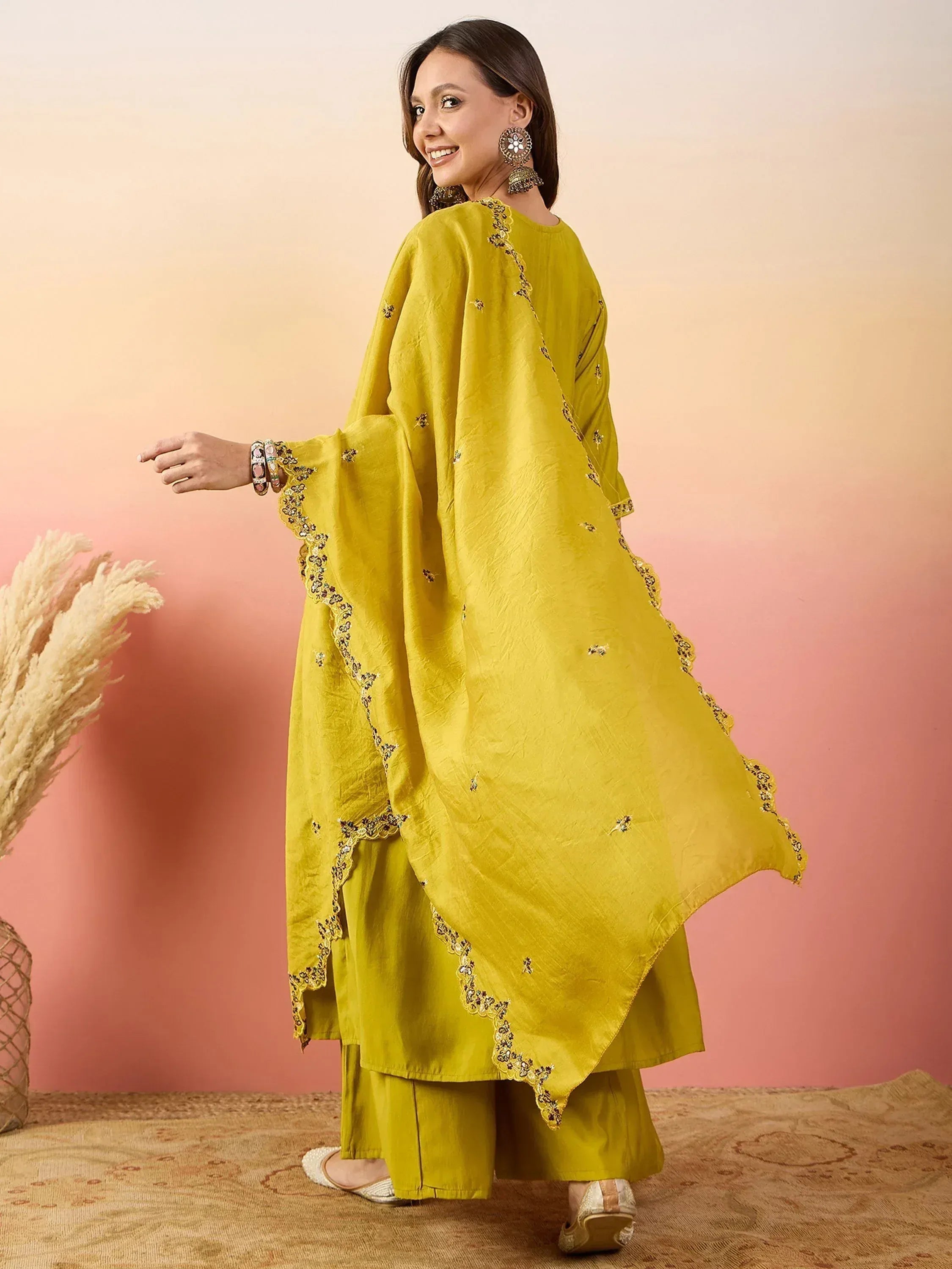 Yellow embroidered ethnic salwar kameez with flared sleeves and mirror work, styled with traditional jewelry