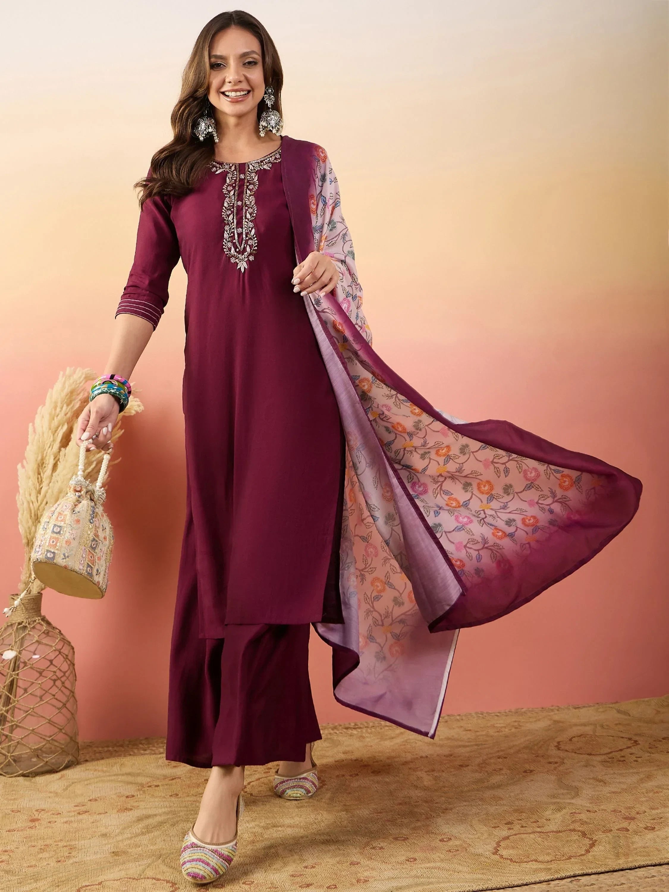 Woman in maroon embroidered salwar kameez with floral dupatta and ethnic accessories