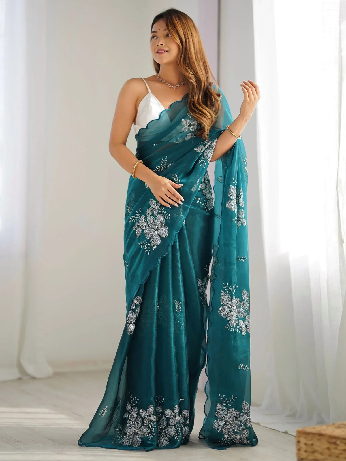 Teal saree with silver floral embroidery, perfect for Indian ethnic wear and festive occasions.