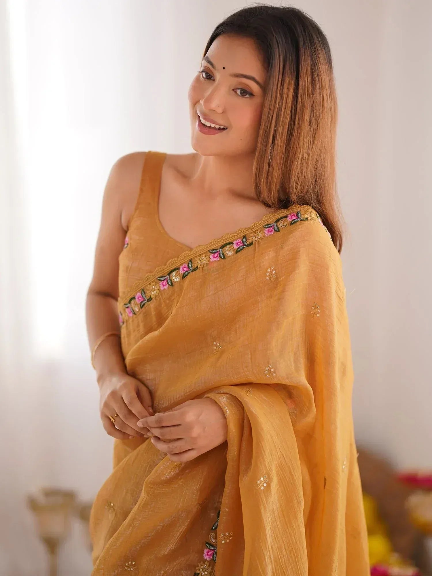 Woman in mustard yellow saree with floral embroidery, perfect for Indian ethnic wear occasions