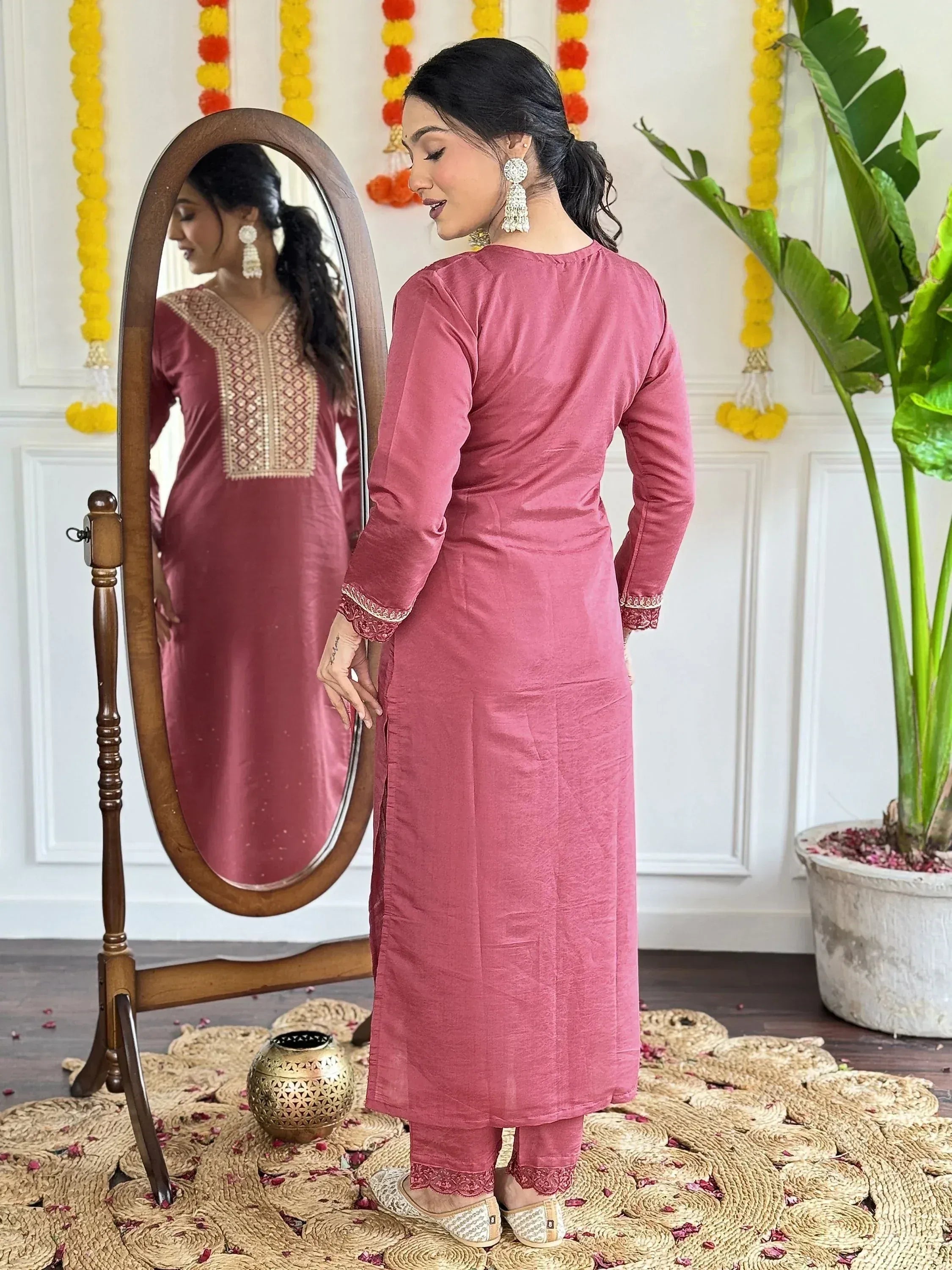 Pink embroidered ethnic kurta with matching pants, mirror reflection, festive decor