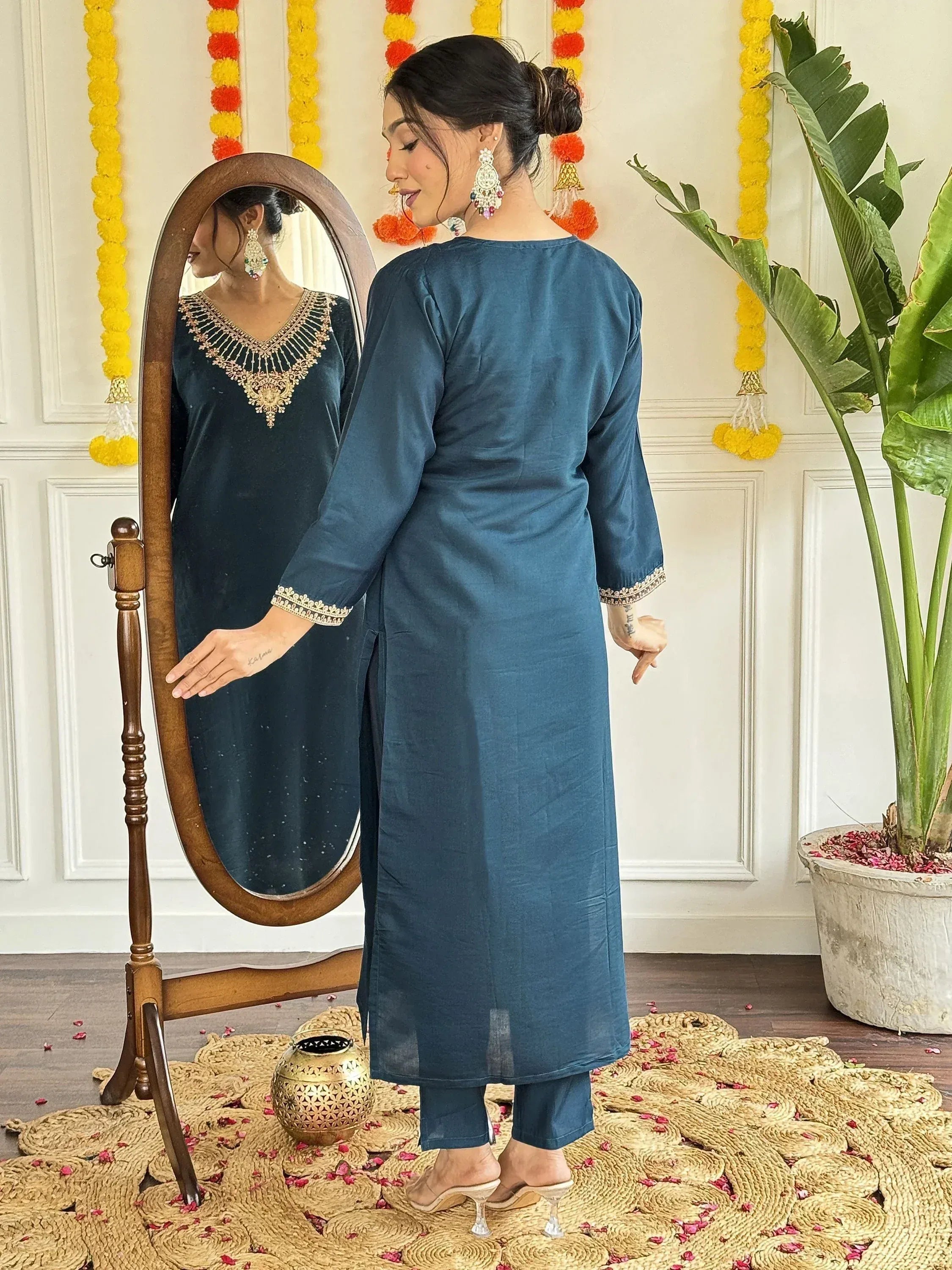 Woman in blue ethnic kurta with gold embroidery, mirror reflection, festive decor