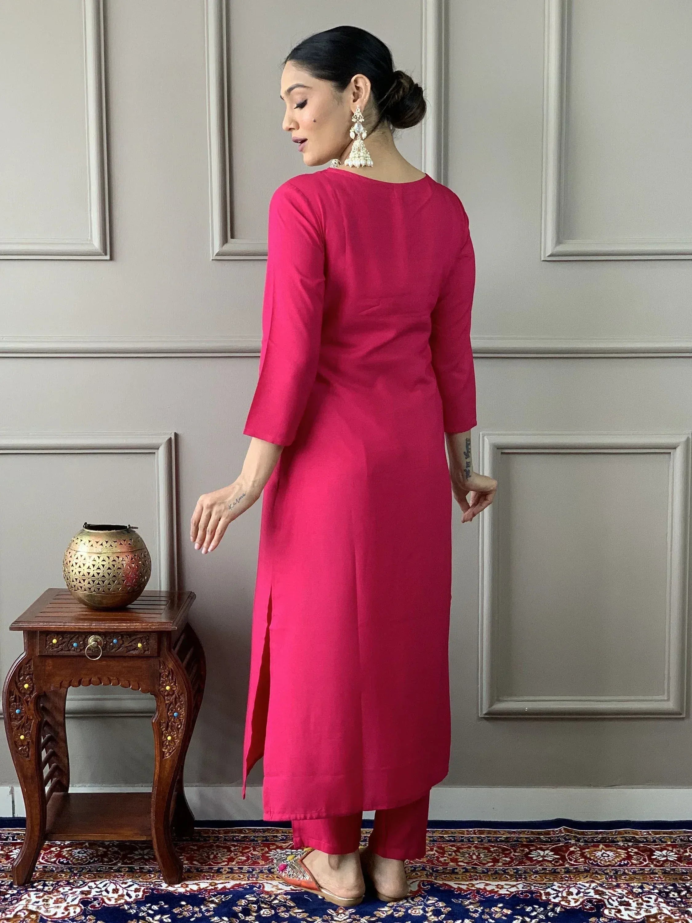 Vibrant pink ethnic kurta with side slits paired with matching pants, styled with jhumka earrings.