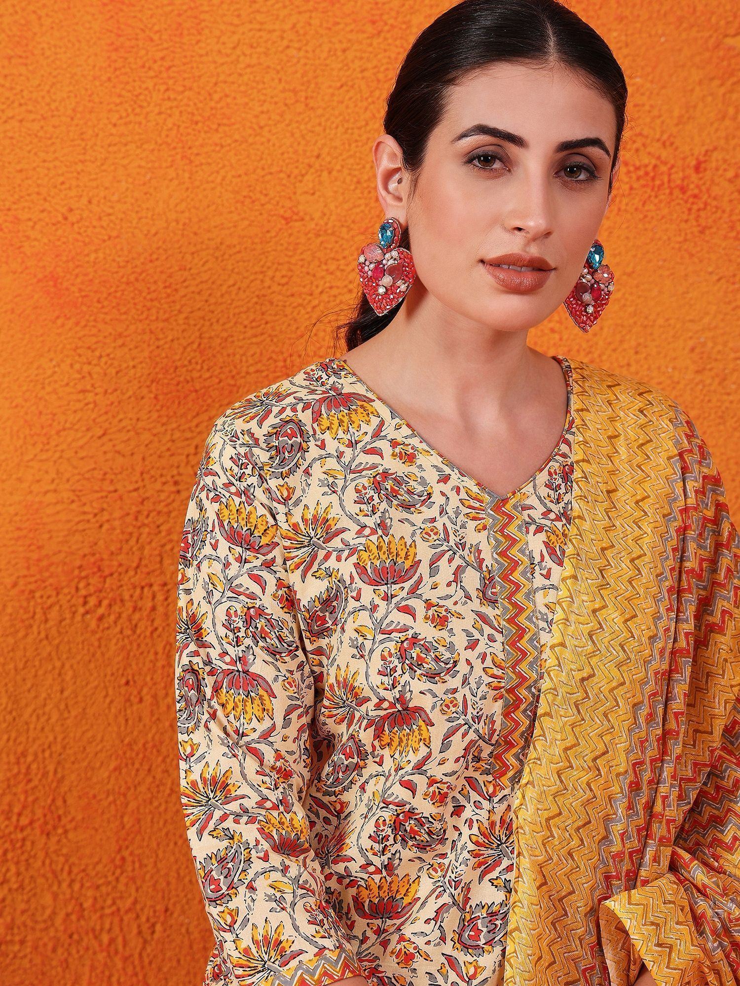 Woman wearing floral print Indian ethnic kurta with yellow dupatta and statement earrings