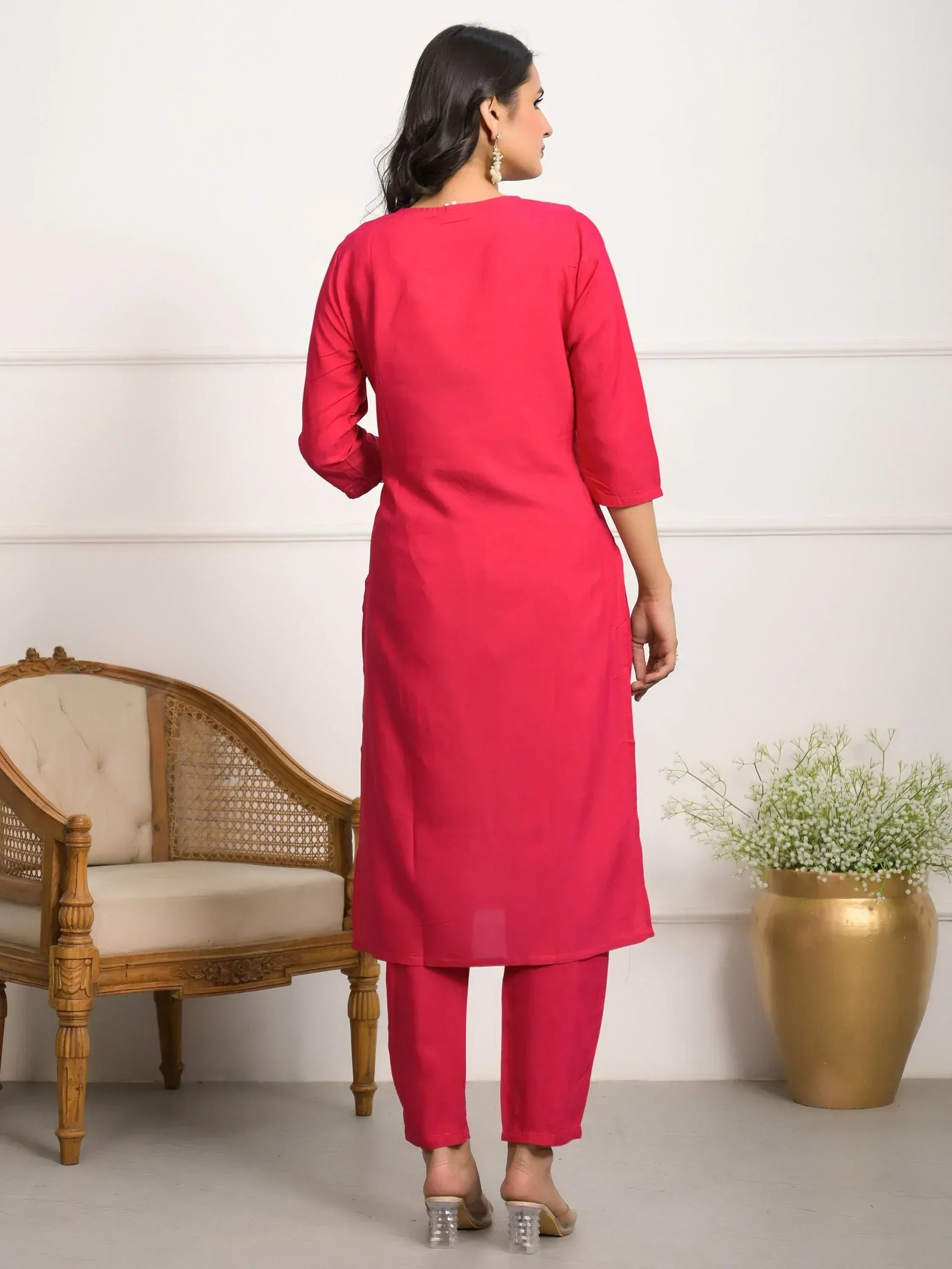 Woman in vibrant pink ethnic kurta and matching pants, back view, stylish Indian wear