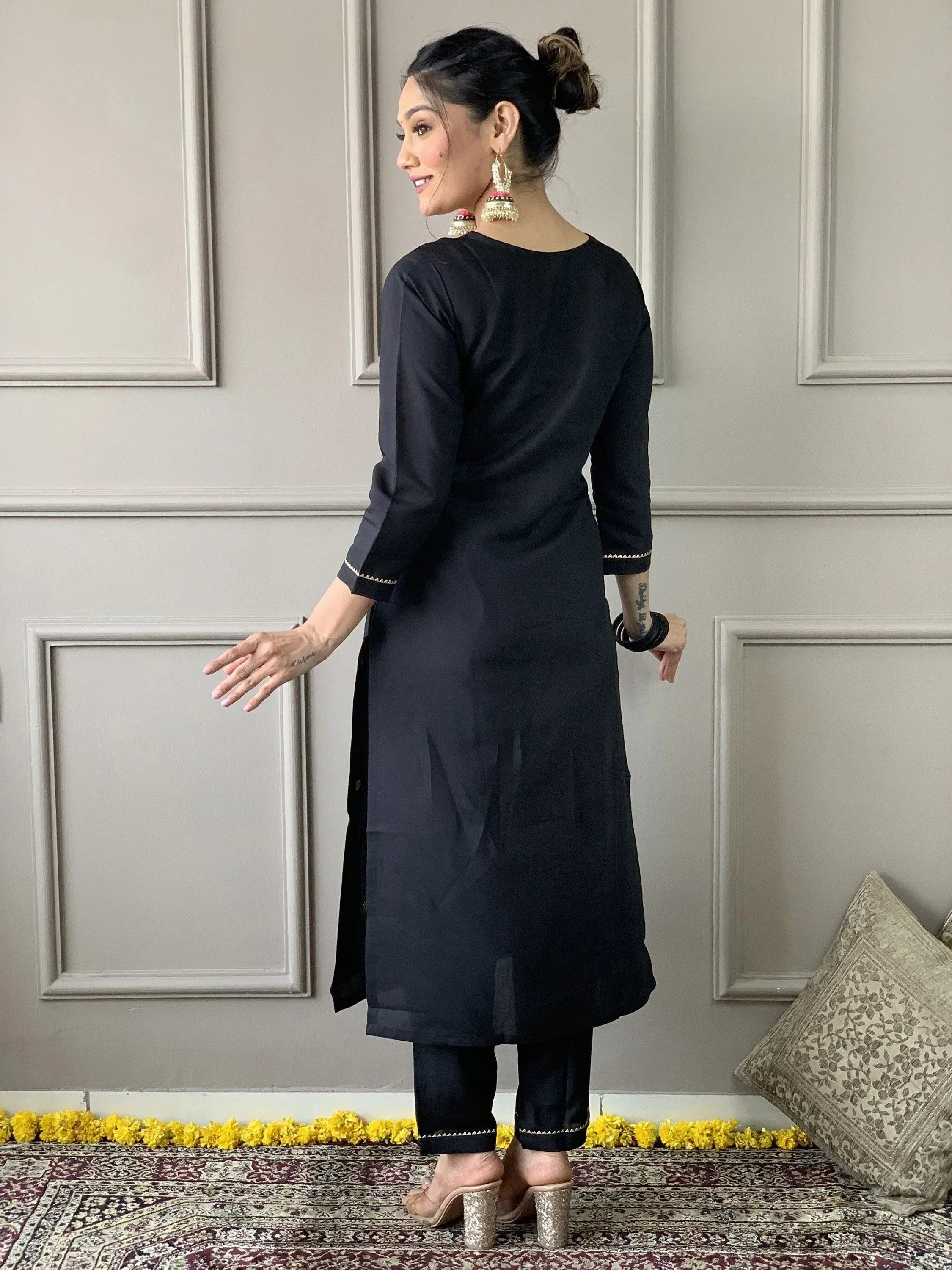 Black ethnic kurta with matching pants, gold trim, and jhumka earrings for Indian wear