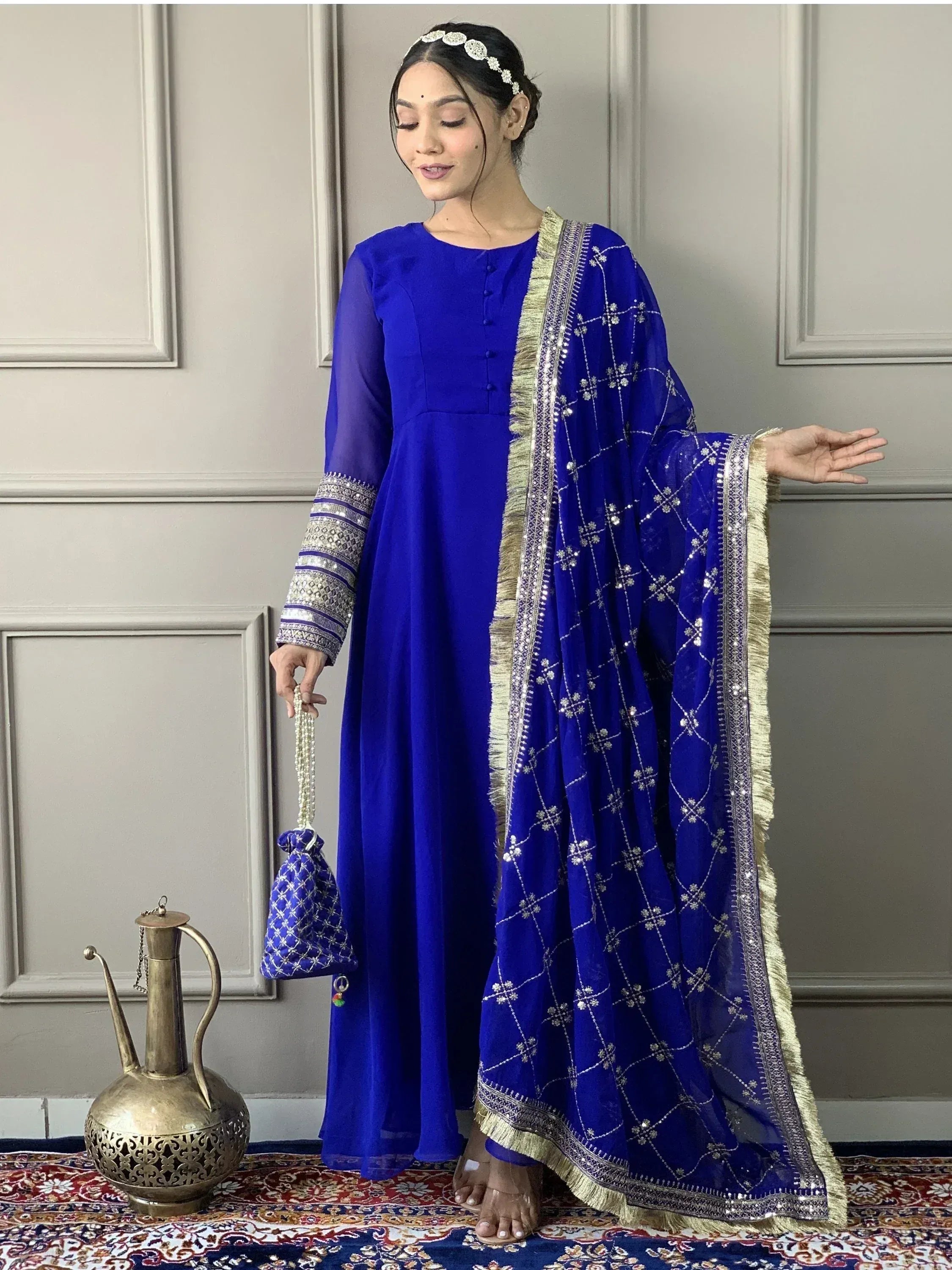 Royal blue ethnic anarkali suit with gold embroidery, dupatta, and matching potli bag for Indian weddings